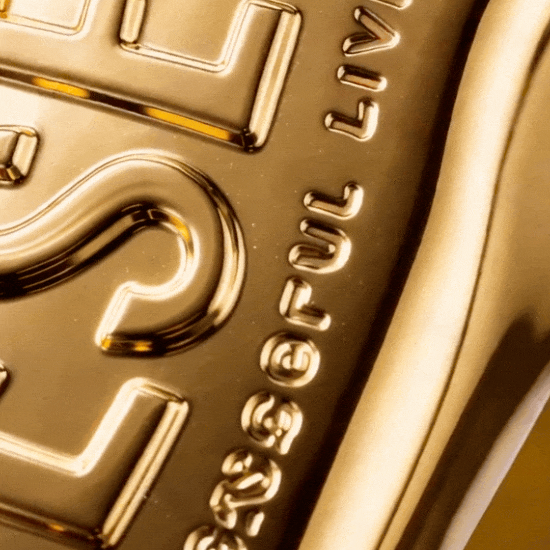 Macro close-up of embossed gold Diesel bottle surface, texture detail for D Pineapple Heat ScentLab concept by WSSC dripping caramel gif