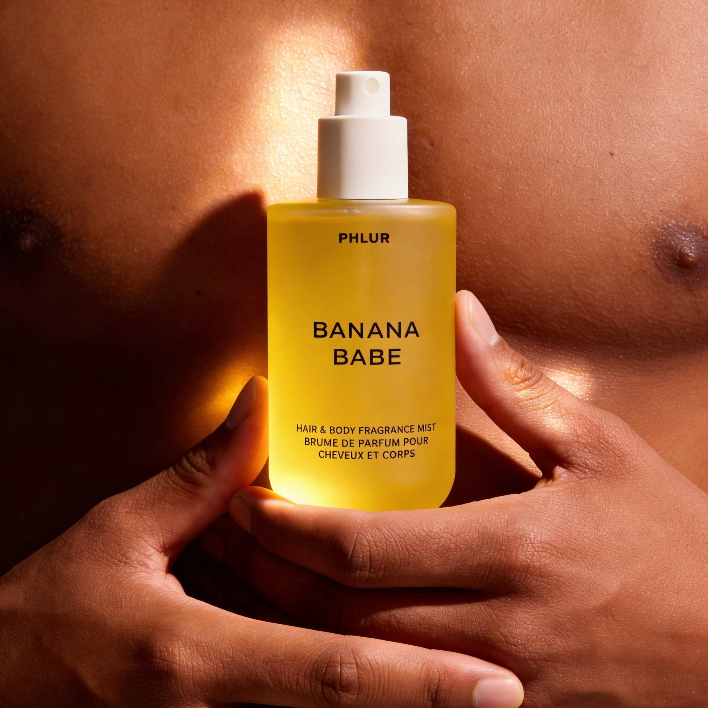 Banana Babe by Phlur – yellow bottle held in warm hands in front of a man's chest ScentLab prospective concept by WSSC