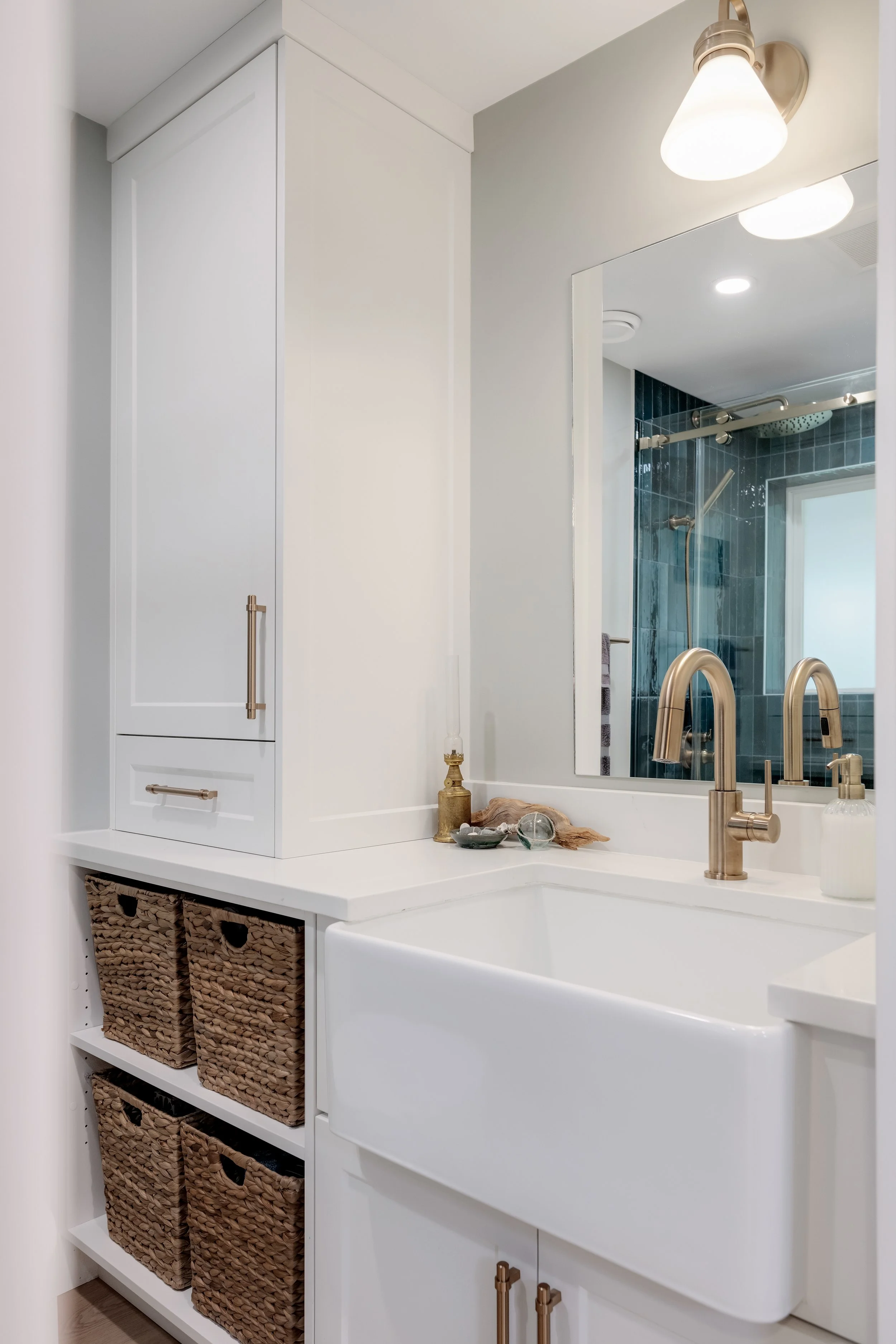 white bathroom with brass hardware and teal shower tile