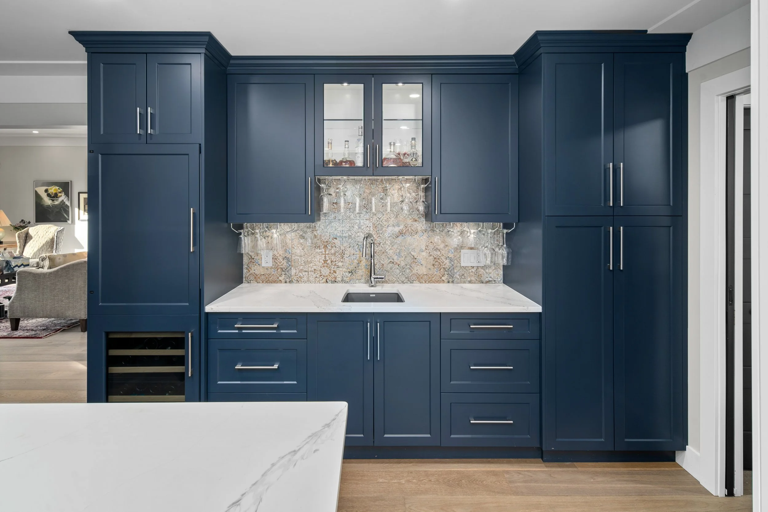 Modern bathroom vanity with black cabinets, two mirrors, and a skylight in the ceiling.