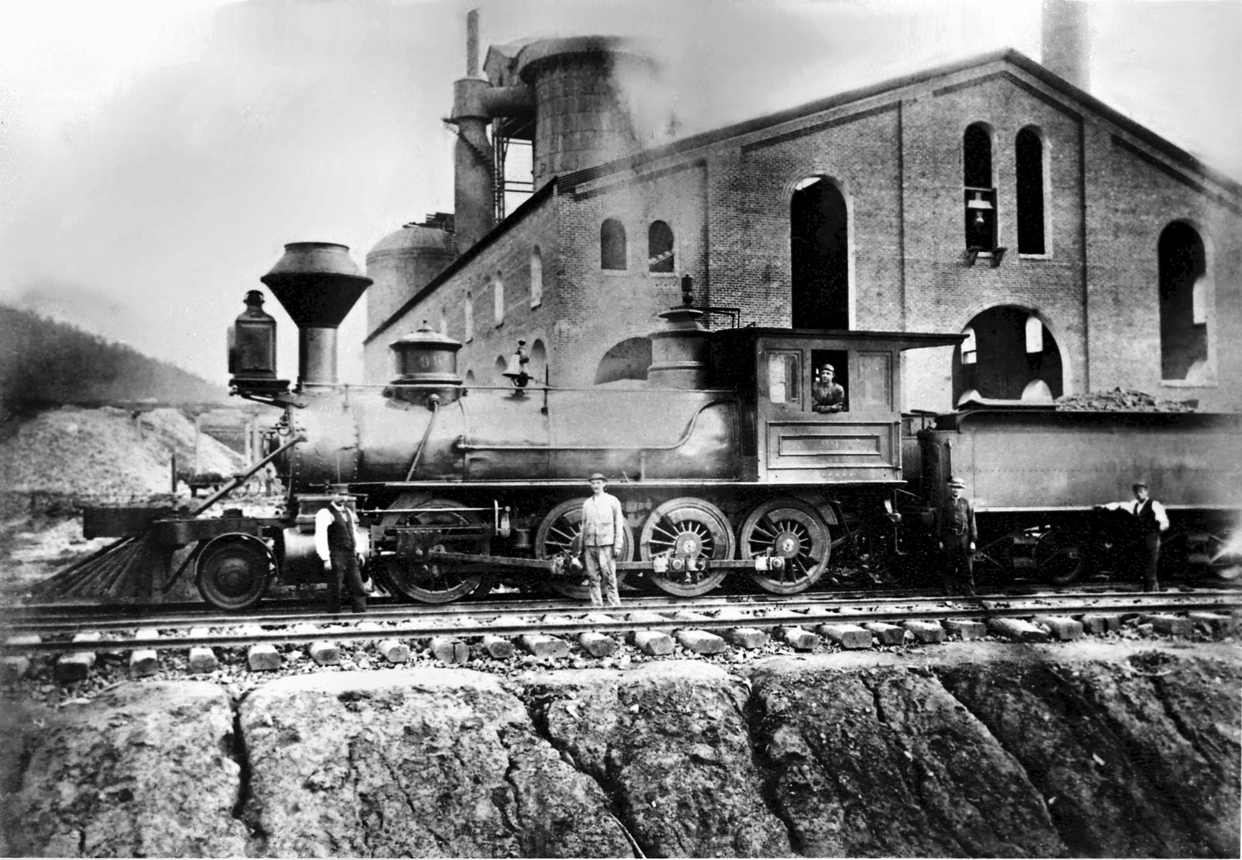 An engine crew poses trackside at Victoria Iron Furnace in Goshen, Virginia circa late 1800's.