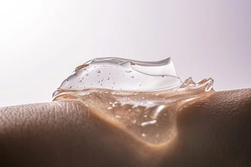 Close-up of a clear gel-like substance on human skin.