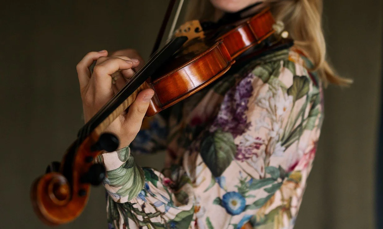 Person playing a wooden violin.