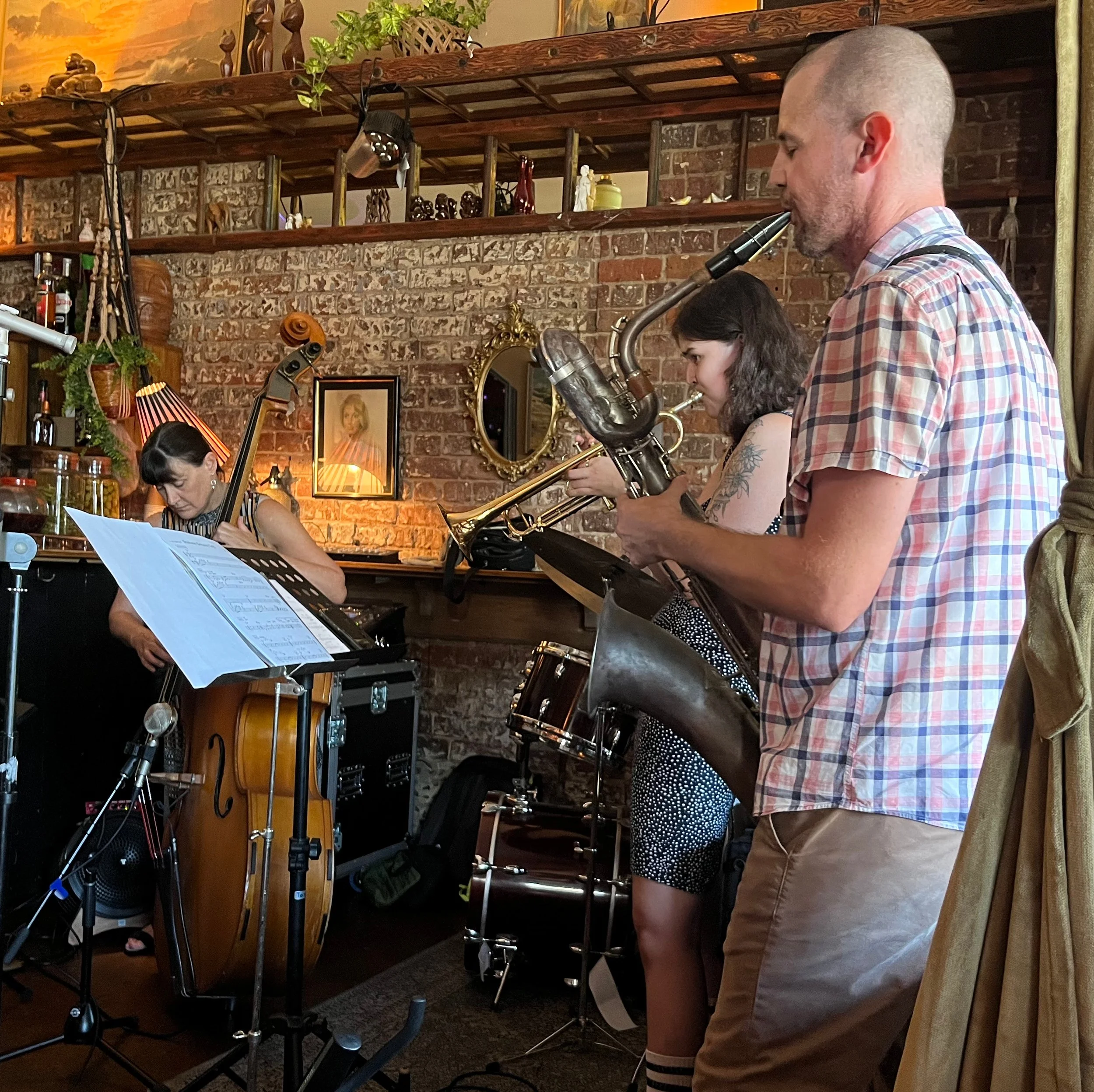 Tabea Sitte-Irwin in a floral dress holding a violin and bow by a window