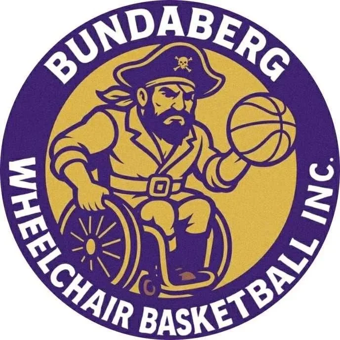 Logo of the Bundaberg Wheelchair Basketball Inc featuring a pirate with a beard, wearing a pirate hat with a skull and crossbones, using a wheelchair, holding a basketball in one hand, and the other hand resting on the wheelchair's wheel.