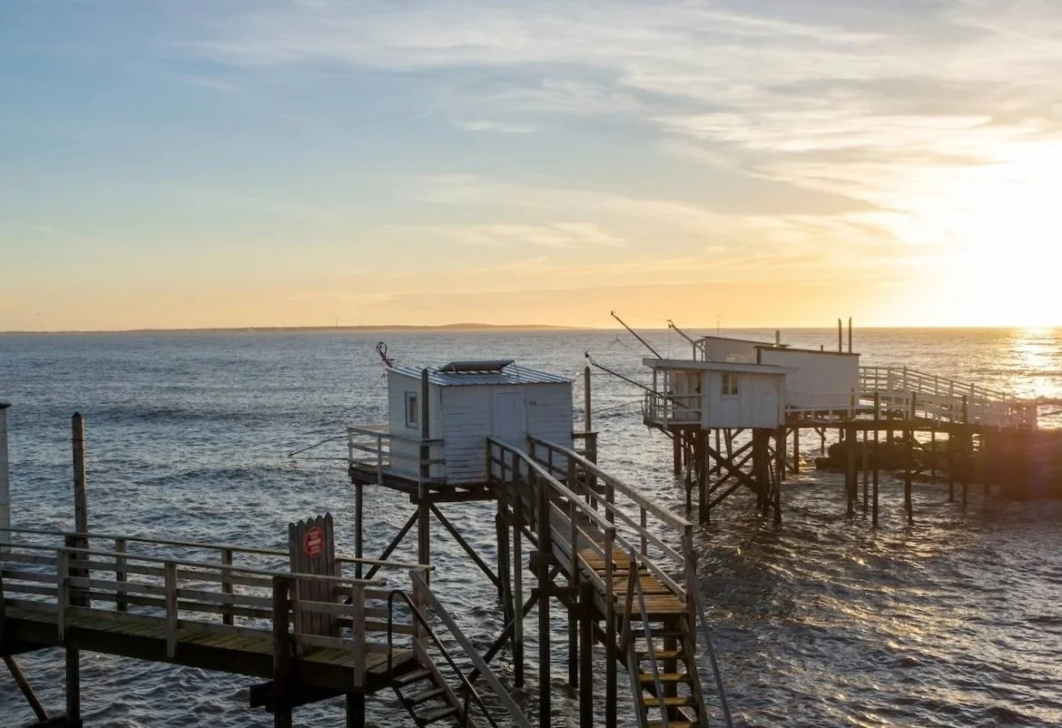 Carrelets Fischerhütten auf Stelzen an der Gironde, Südwestfrankreich, über dem Wasser mit blauem Himmel