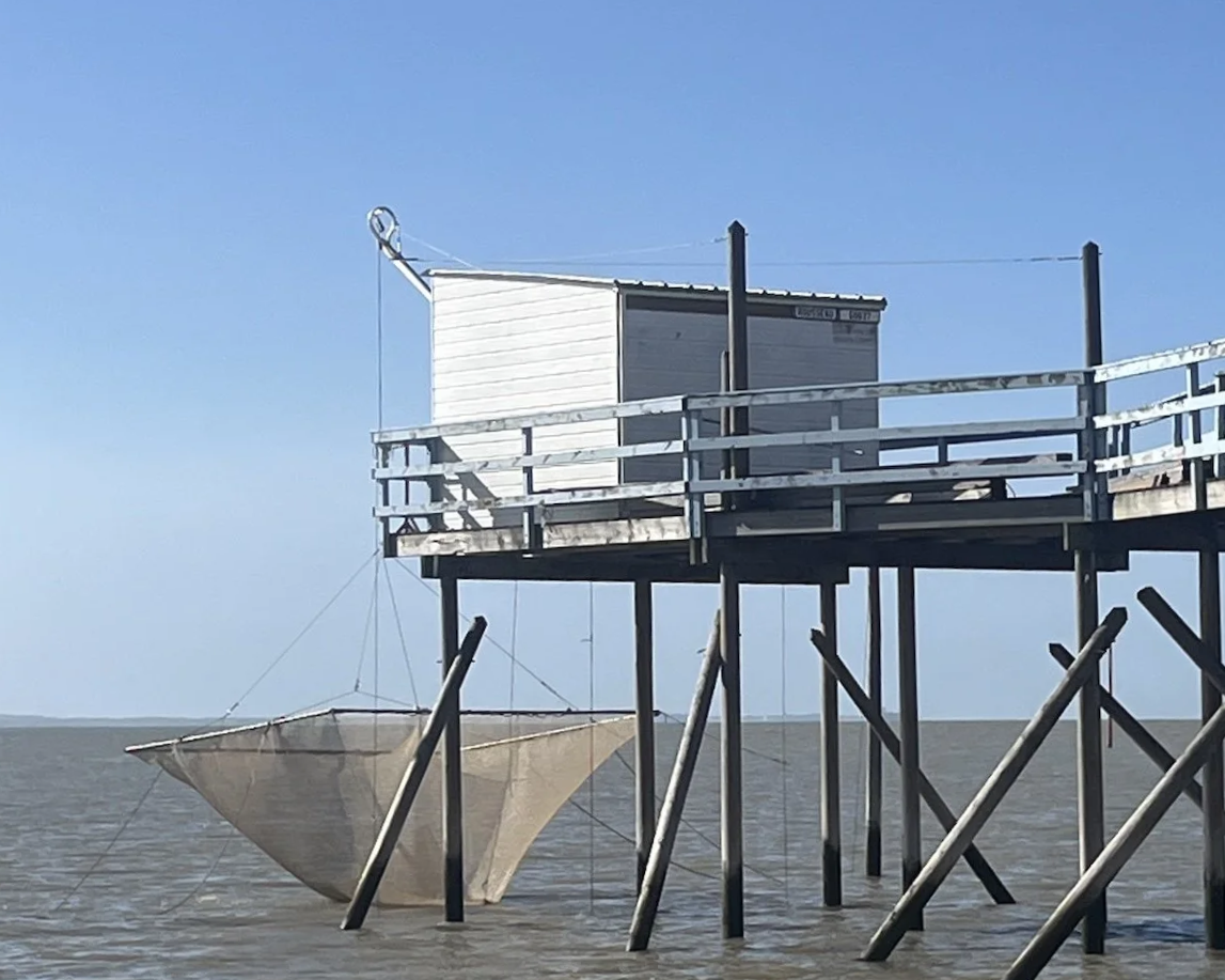 inzelne Fischerhütte an der Gironde, Südwestfrankreich, mit aufgehängtem Fischernetz
