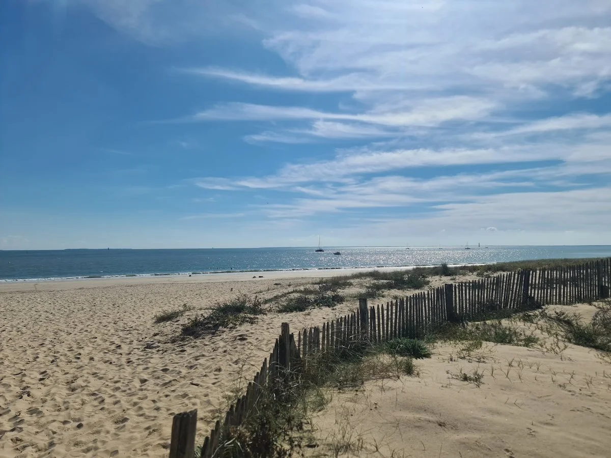 Strandzugang auf der Île de Ré, Frankreich, mit Sandweg zum Meer und Dünen im Hintergrund
