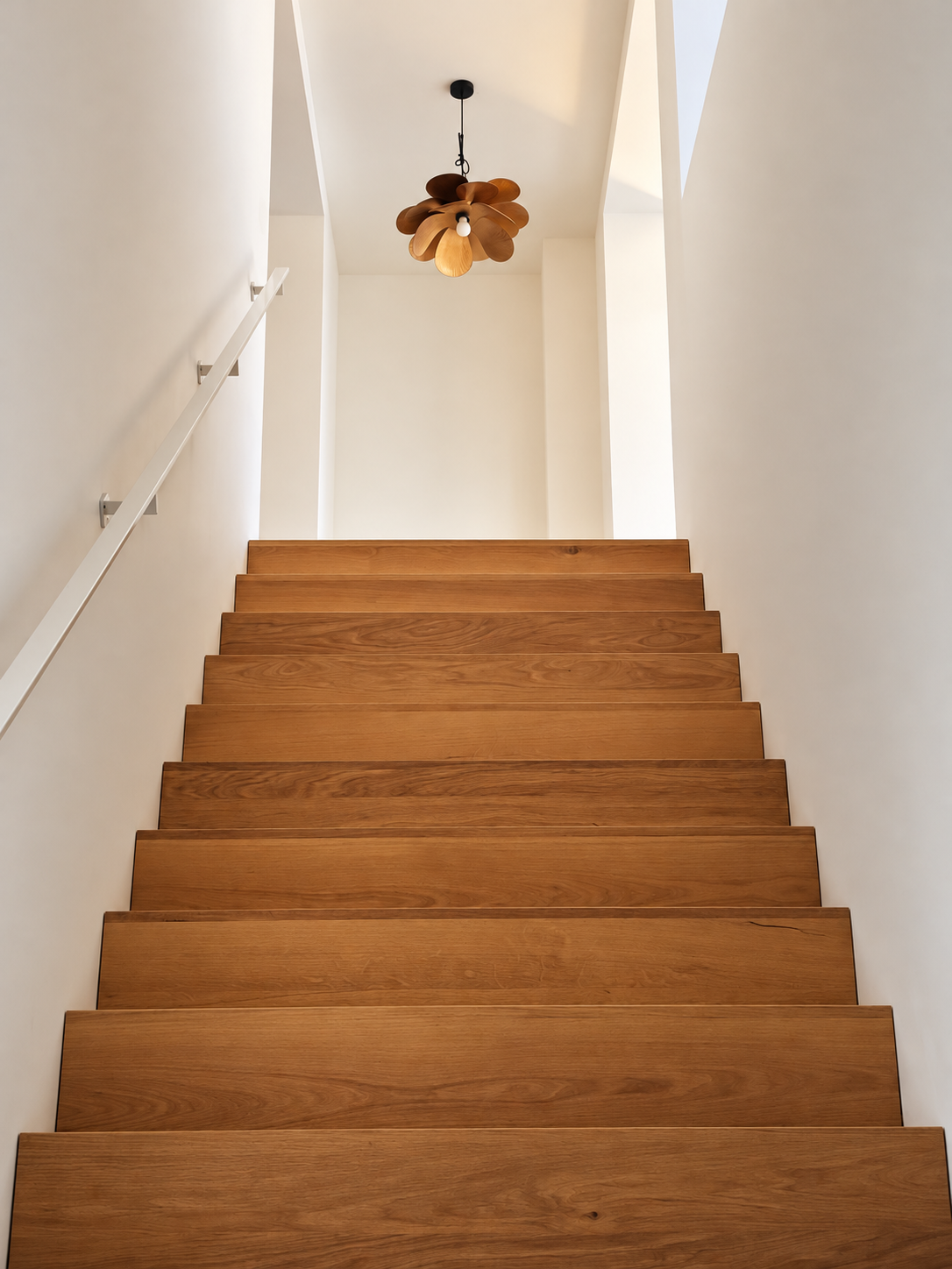 Minimalistische trap met houten hanglamp.png