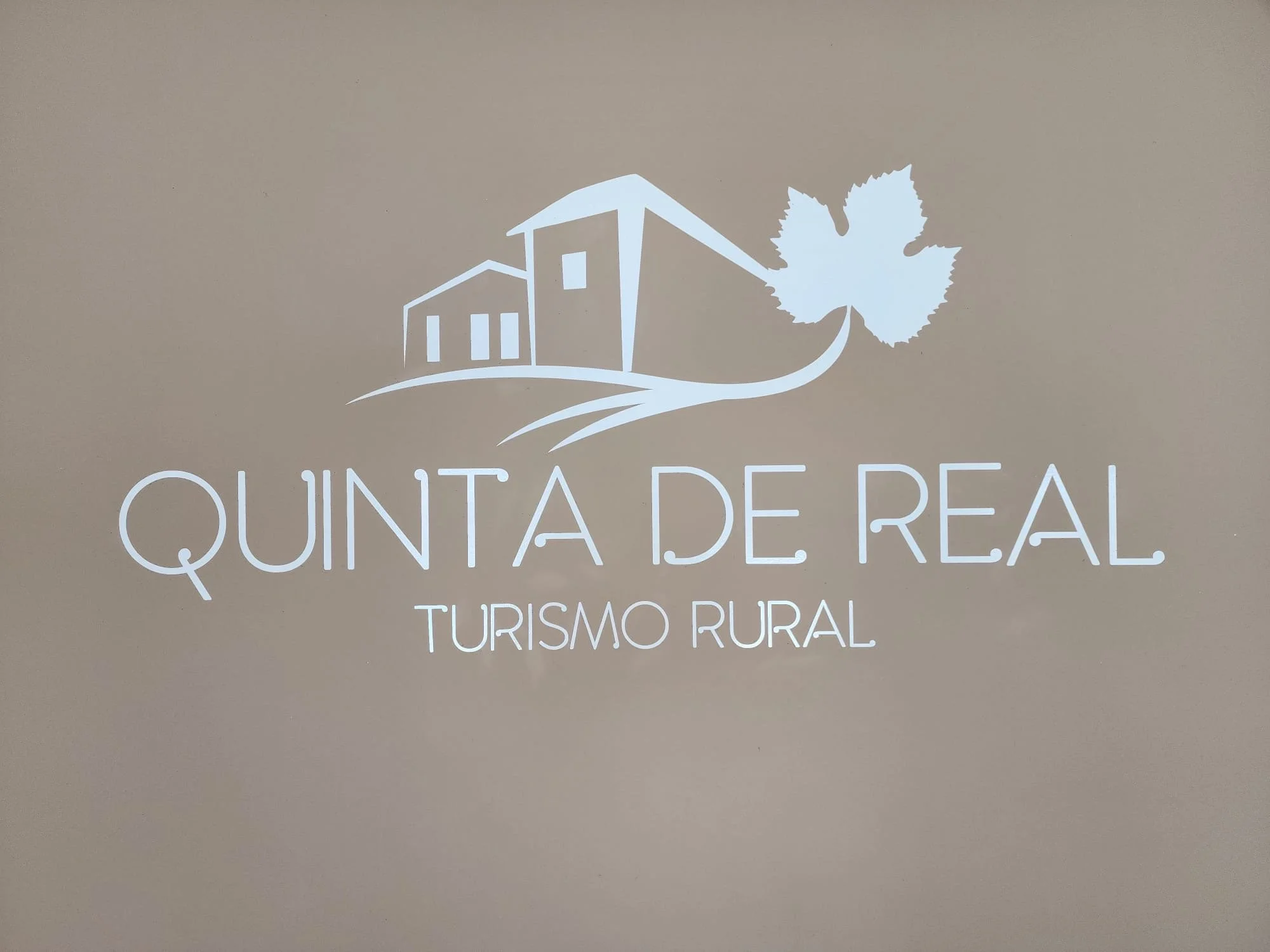 Landscape of mountains, a lake, and rolling hills with grass and shrubs under a cloudy sky.