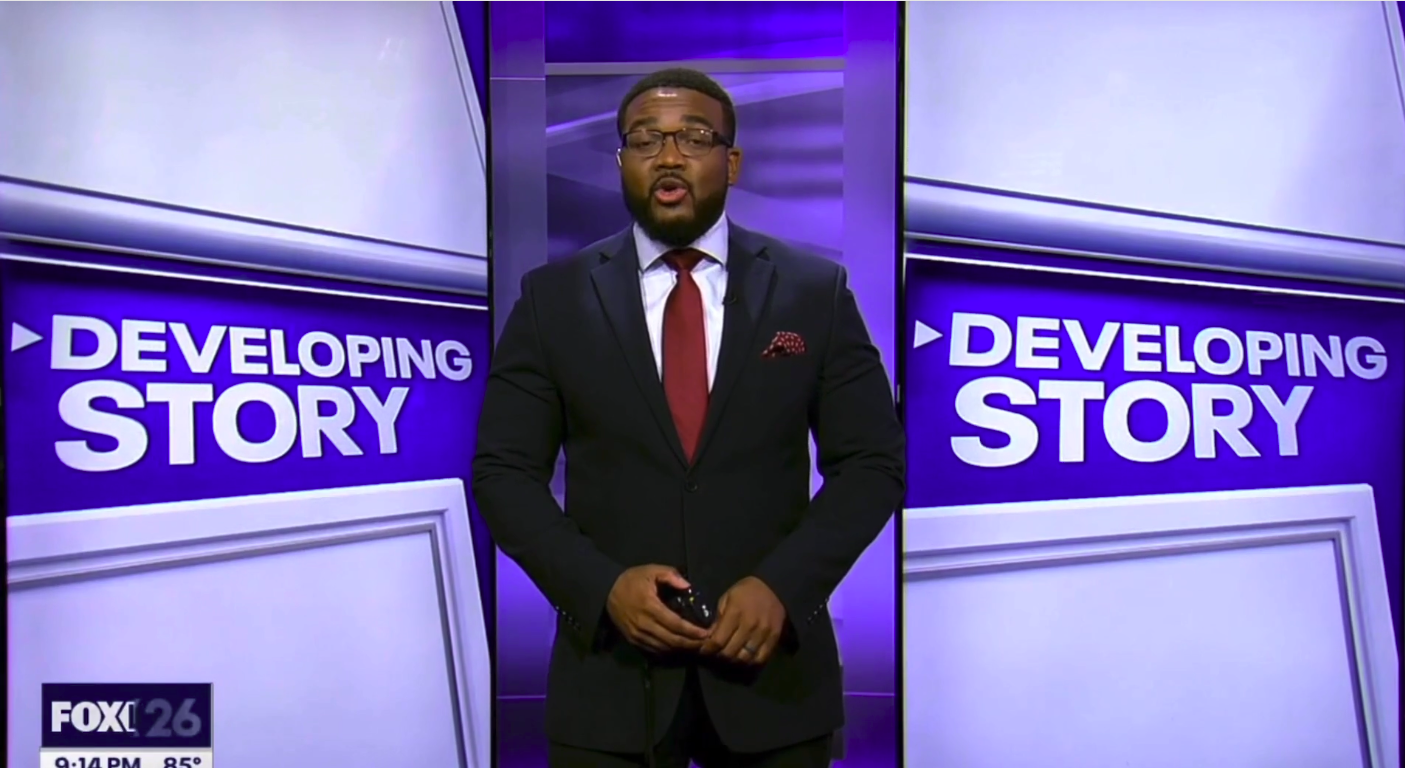 Black man in a developing story interviewing Juan Guevara Torres bilingual tech expert