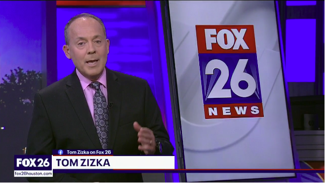 News anchor Tom Zizka reporting at Fox 26 News studio with a large Fox 26 logo on screen behind him.