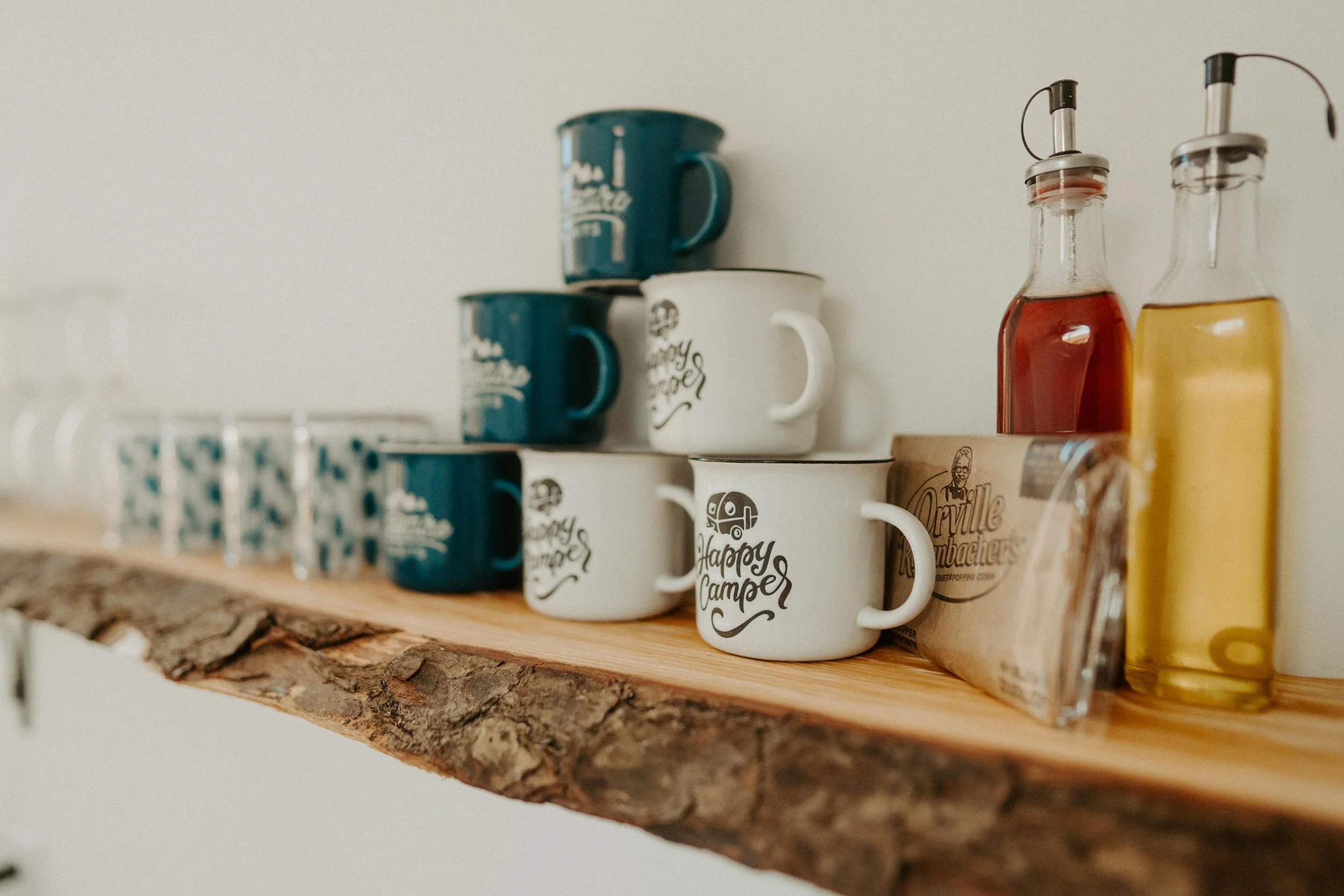 Coffee mugs stacked on a wooden shelf, two with 