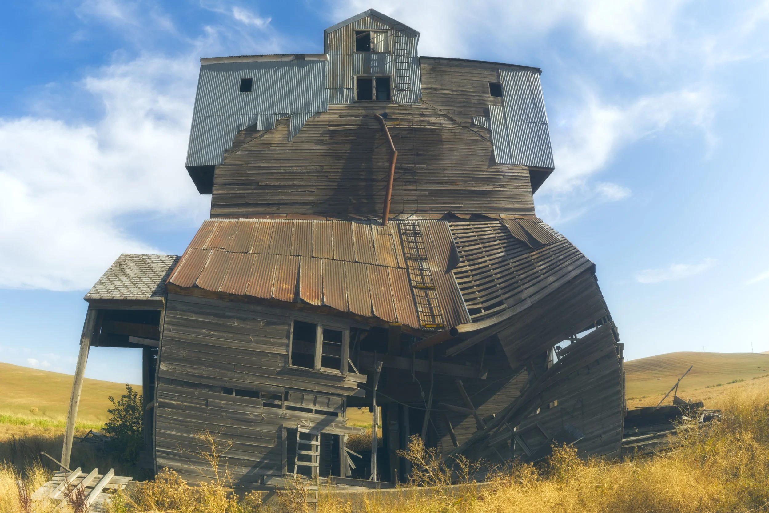 abandoned-grain-elevator-looks-like-a-home-pullman-u-s-195-palouse-wheat-fields-rolling-hills-old-metal-work-down-washington-494-color-and-photo-labs-color-grading-kodak-portra-400-120.jpg