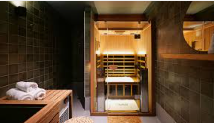 Indoor luxury sauna with wooden benches and warm lighting.