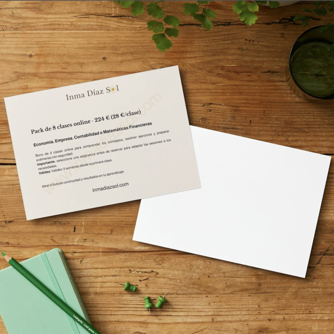 Bono de 8 clases de Economía y Empresa, Contabilidad y Matemáticas Financieras, acompañado de un cuaderno verde, un bolígrafo y clips de colores sobre una mesa de madera.