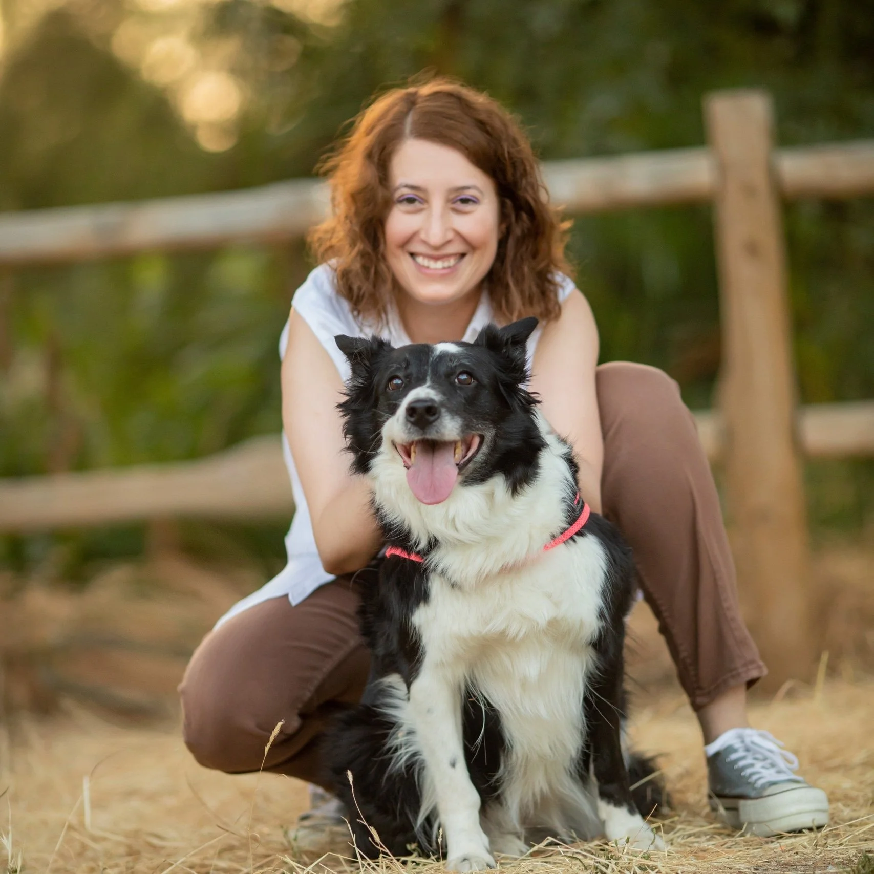 Mujer sonriendo con un perro Border Collie en un parque