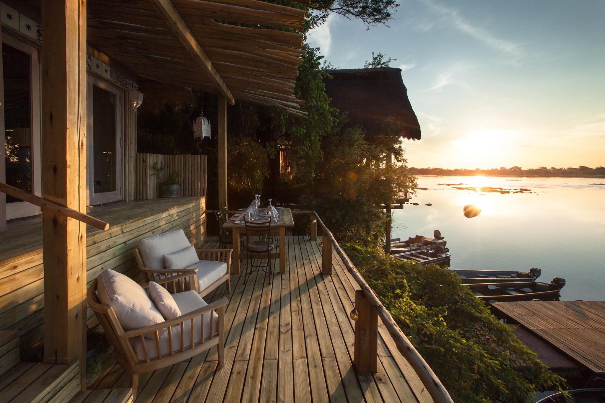 Terrasse eines Zimmers in einer Luxus-Safari-Lodge in Sambia mit Blick auf den Zambezi River bei Sonnenuntergang
