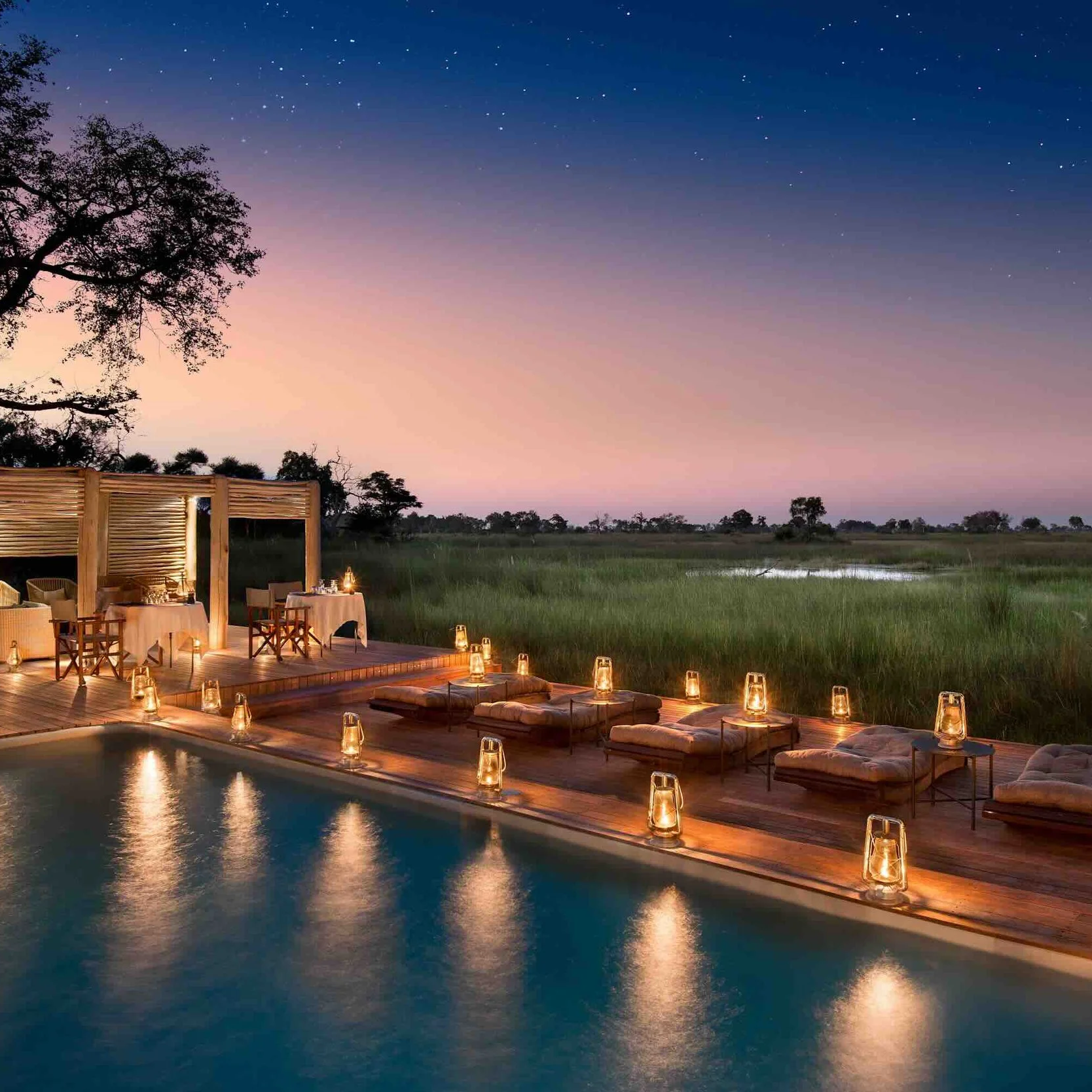 Pool einer Luxus-Safari Lodge im Okavango Delta in Botswana mit Kerzenschrein und Blick auf das Delta