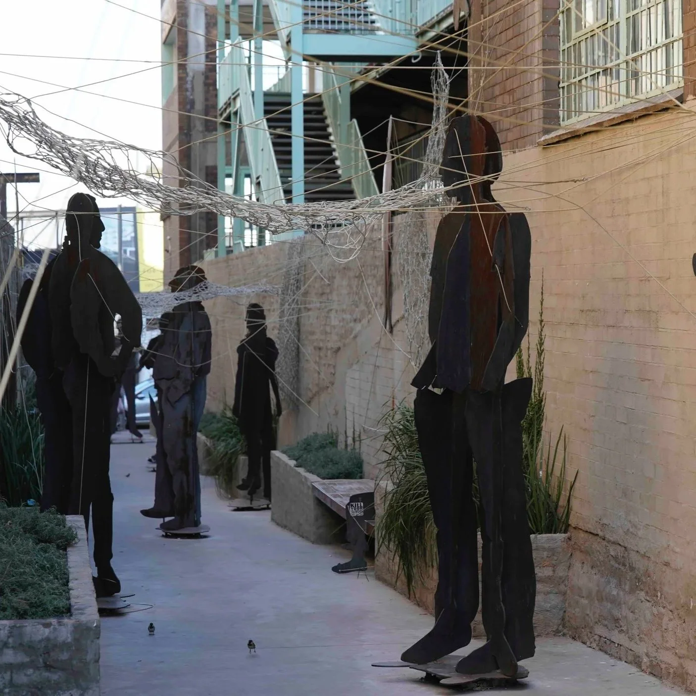 eine Kunstinstallatoin mit Menschen aus Stahl in Johannesburg in Südafrika