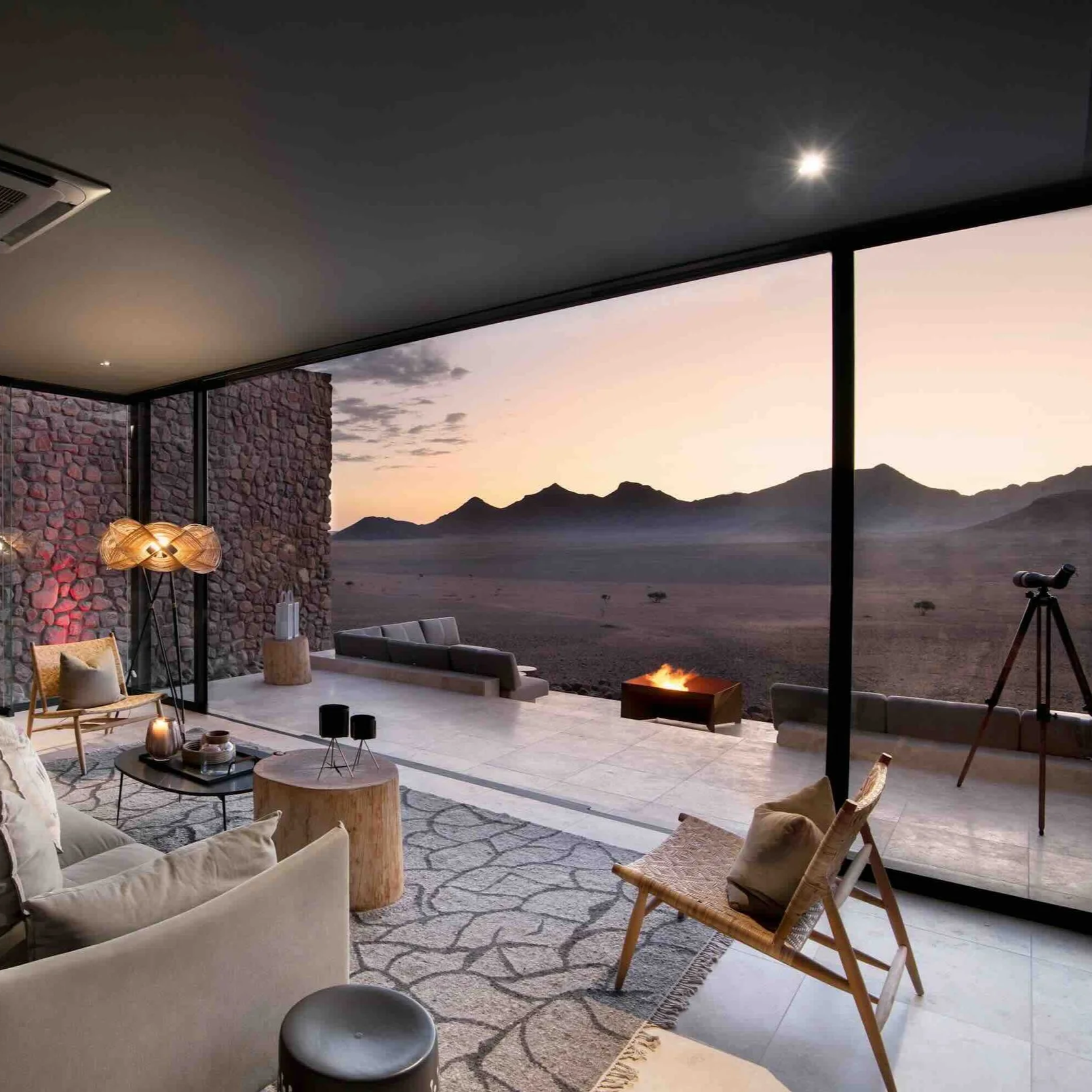 Luxuriöses Zimmer mit großem Panoramafenster, Terrasse und Feuerstelle mit Blick in die Wüste in Nambia