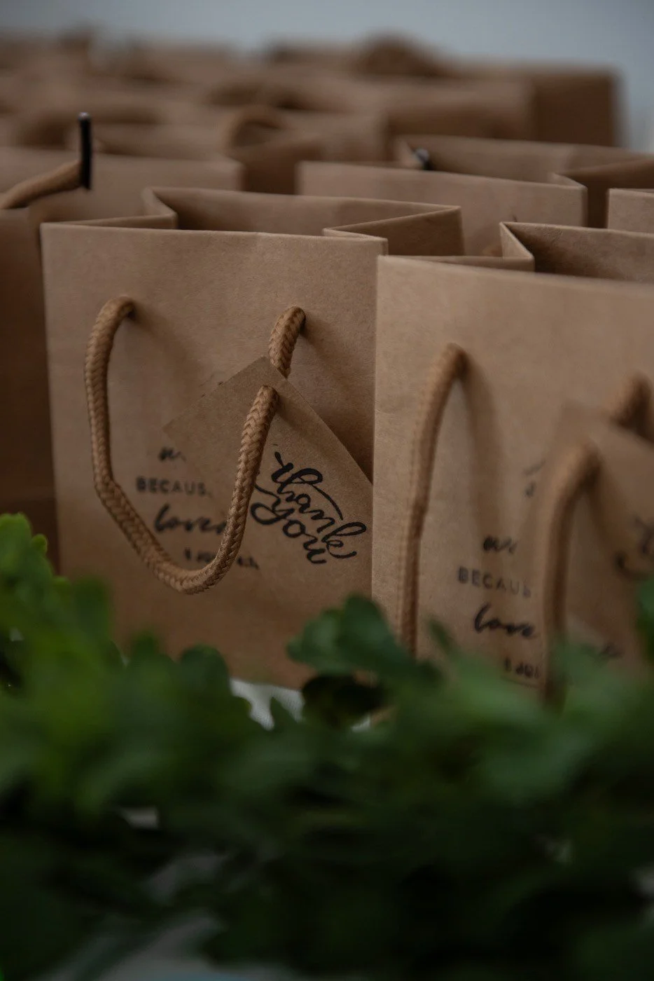 Wedding table decor with guest favors and greenery.