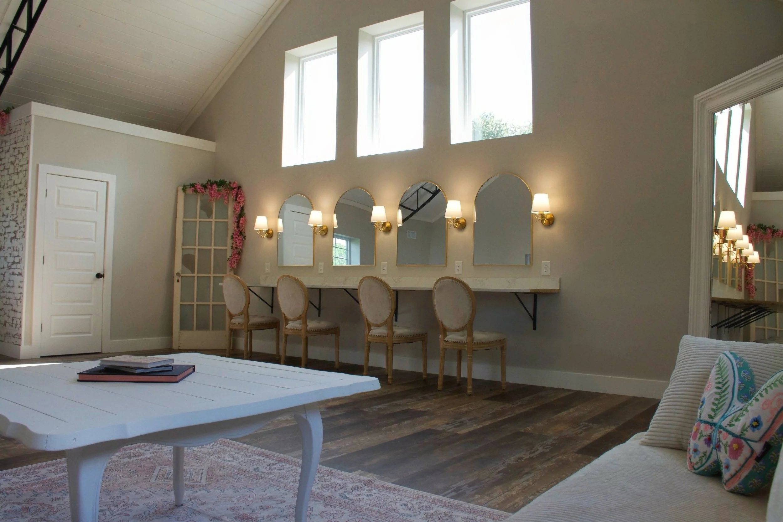 Bright bridal suite with natural light, mirror stations, and lounge area for getting ready photos.