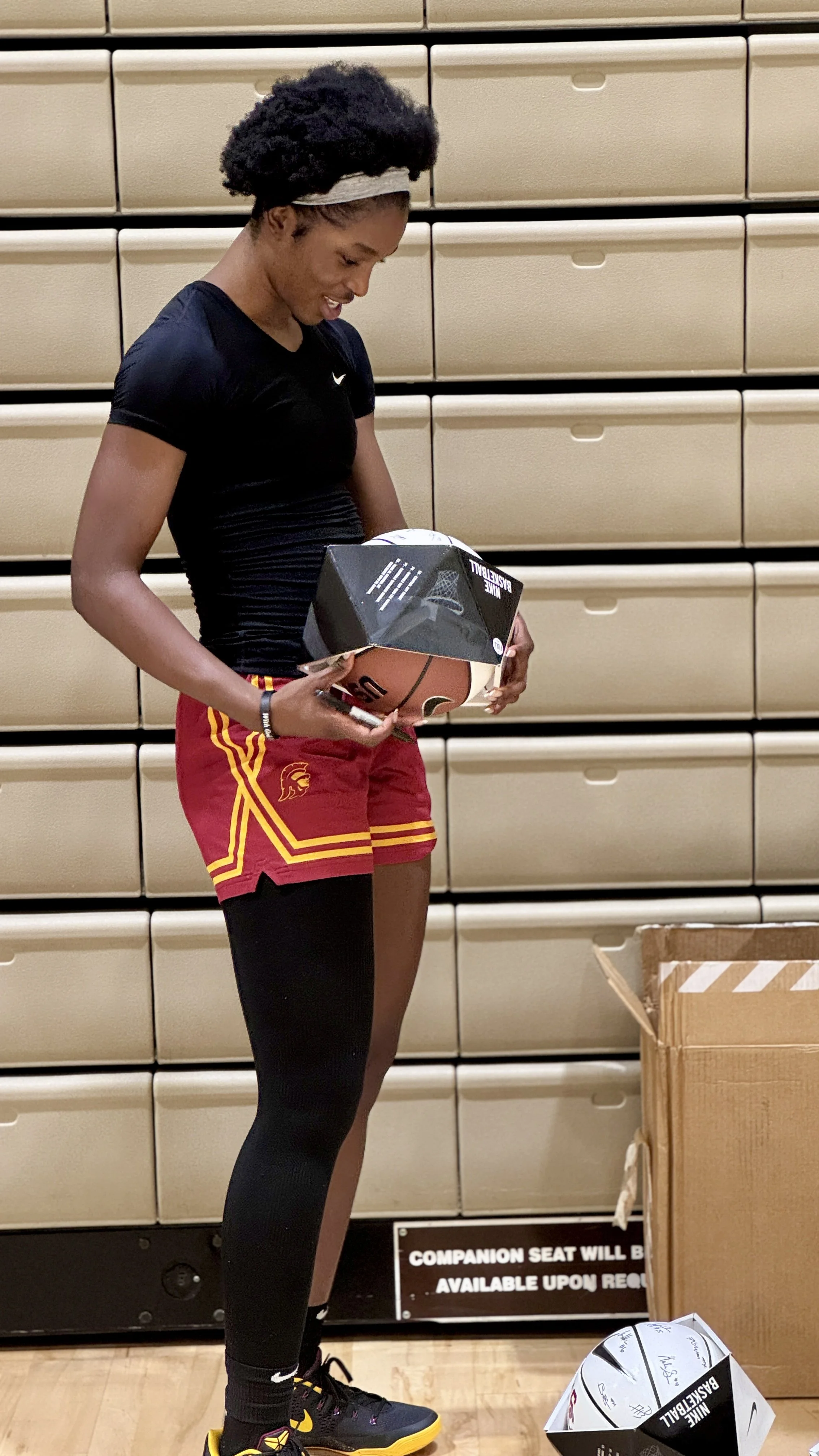 Viv Signing a basketball for an event
