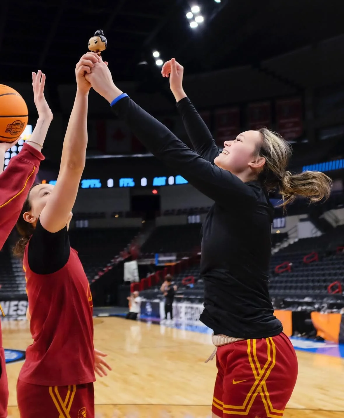 USC teammates holding the juju doll during practice