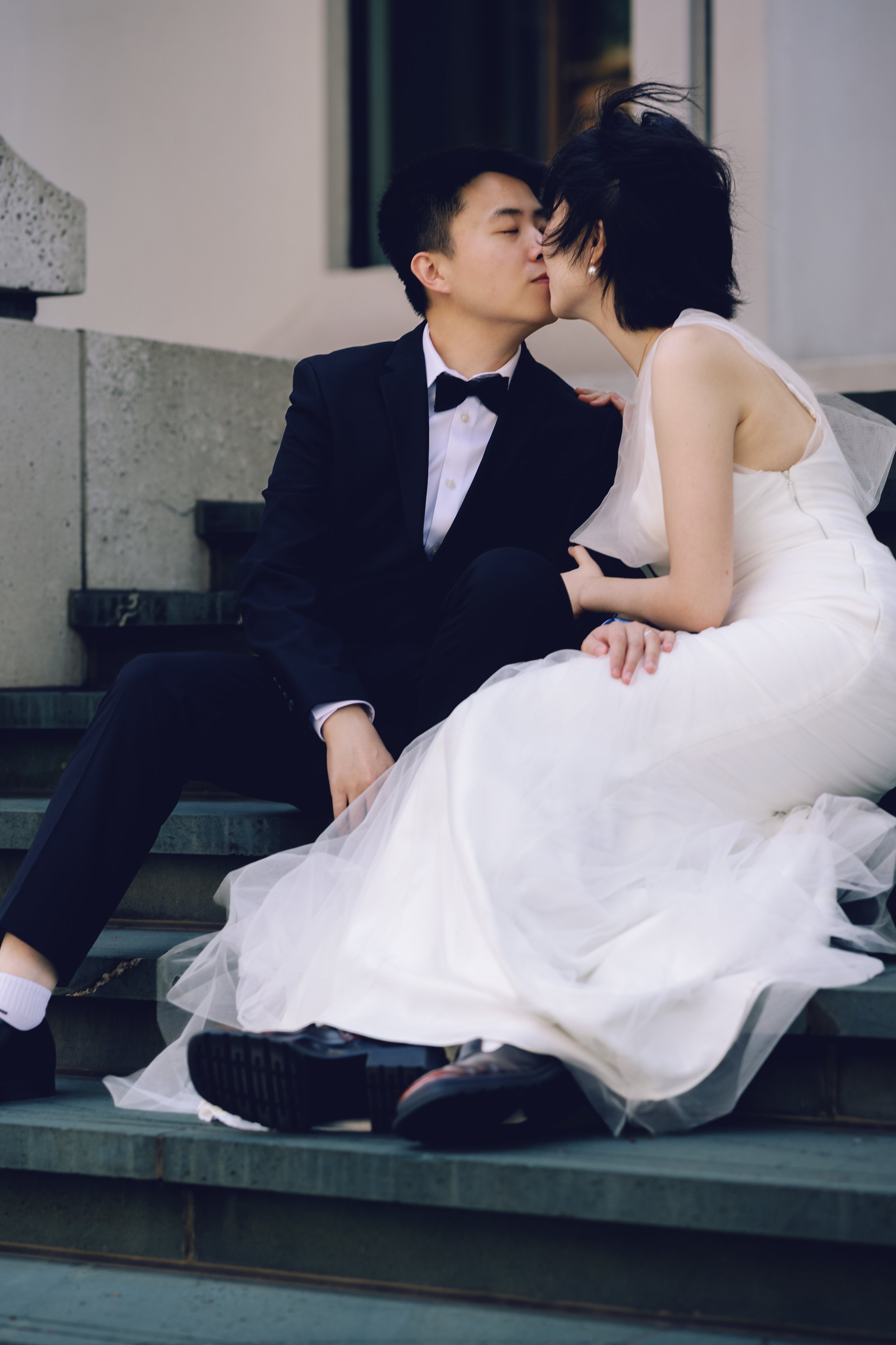 Couple kissing on stone steps during an editorial engagement session.