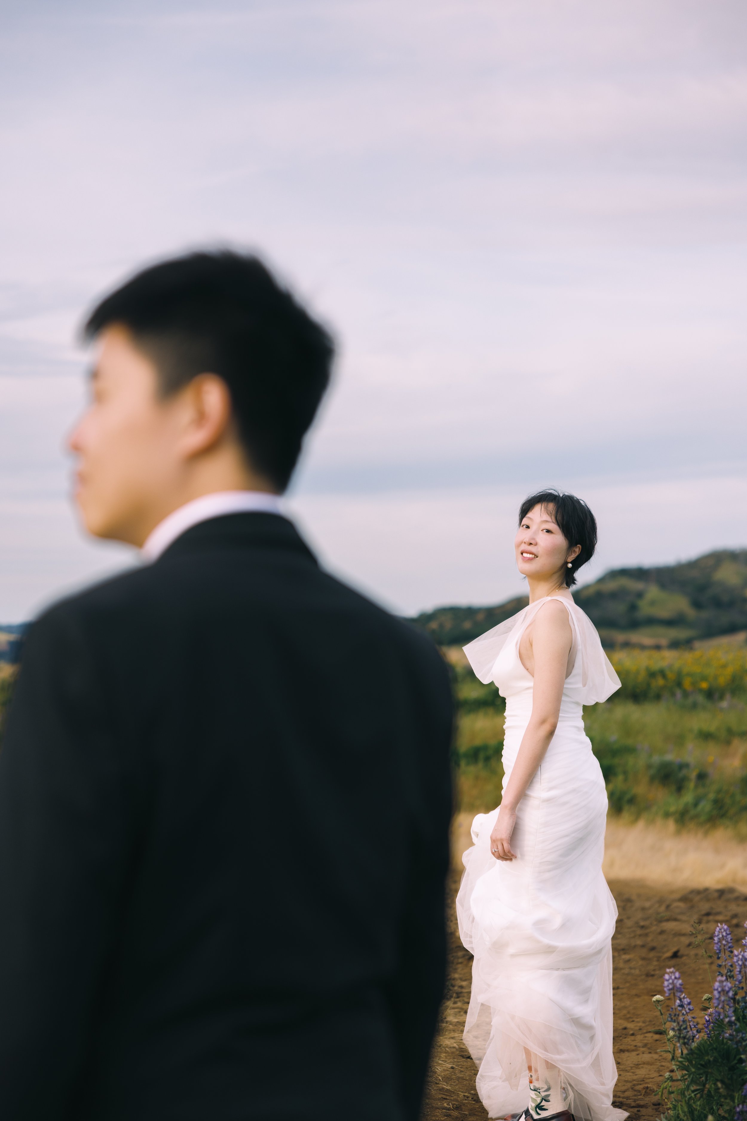 Bride looking back toward the groom during a soft, editorial portrait at Tom McCall Preserve.