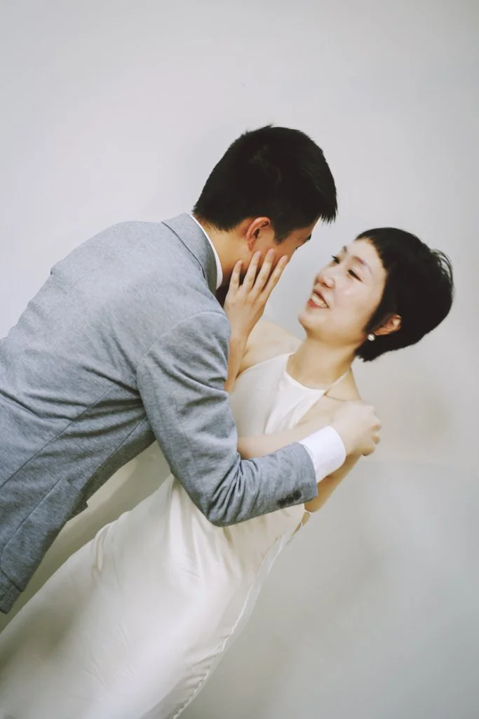 Bride holding the groom’s face during a quiet, intimate wedding moment.