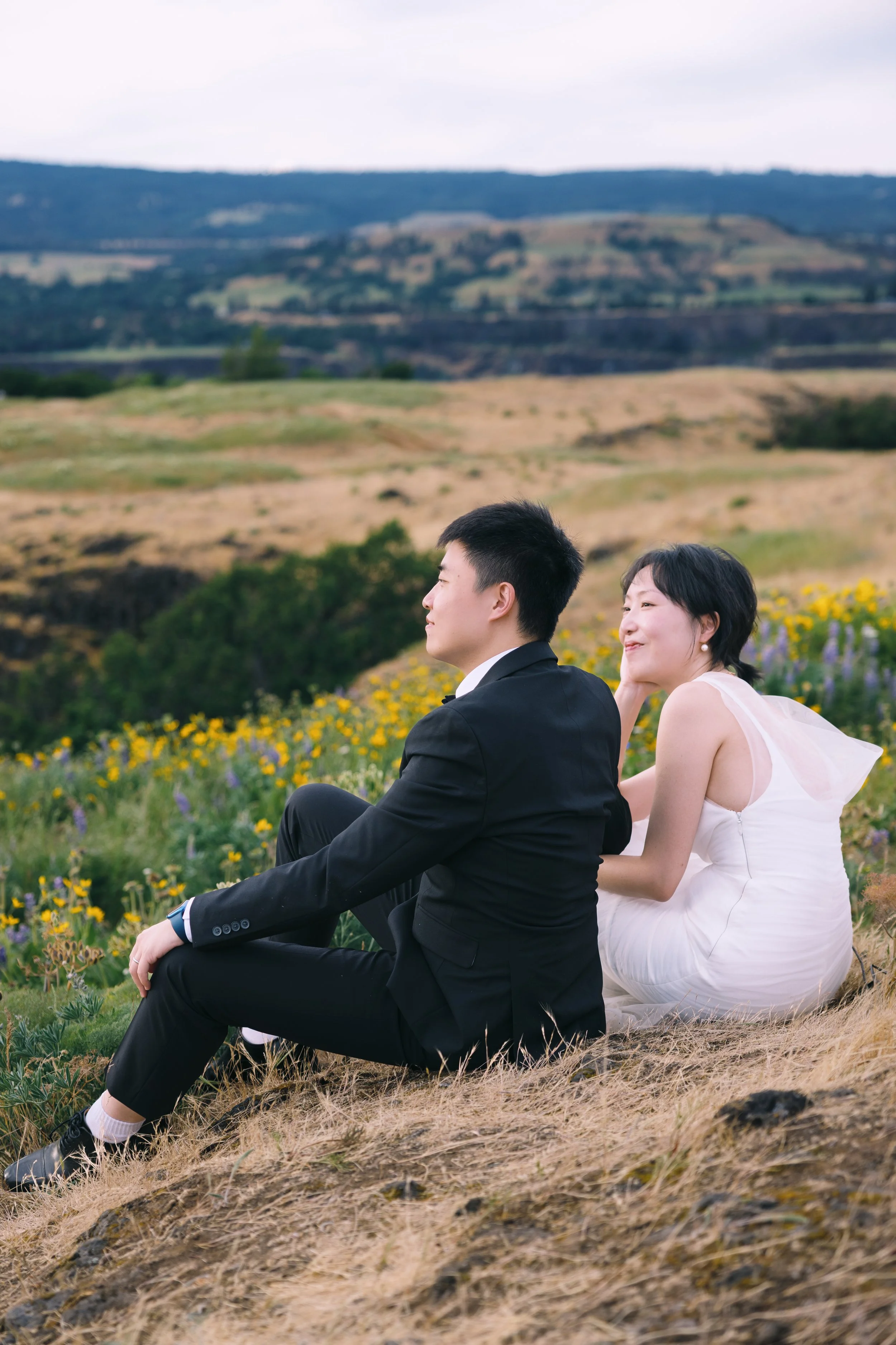 Engaged couple seated together overlooking the hills at Tom McCall Preserve.