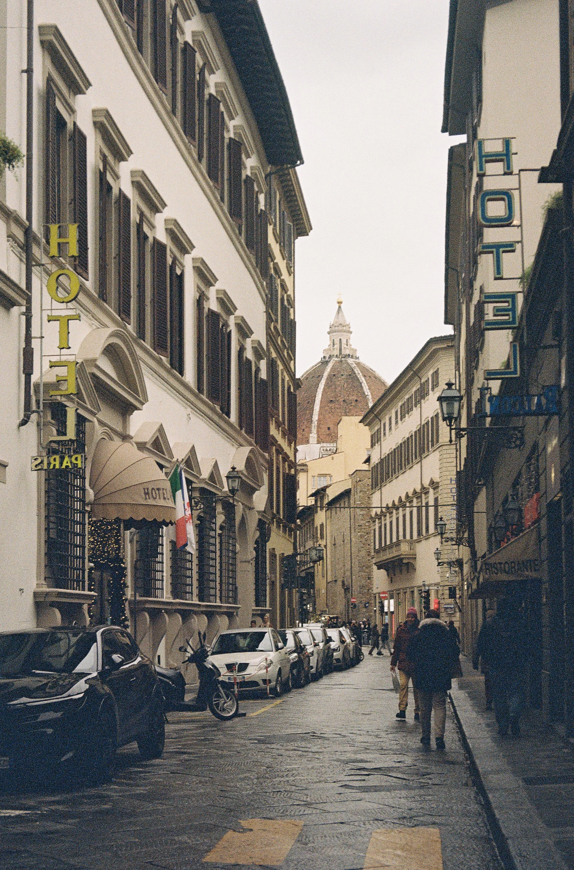 A quiet street in Florence with the Florence Cathedral (Duomo) in the distance.
