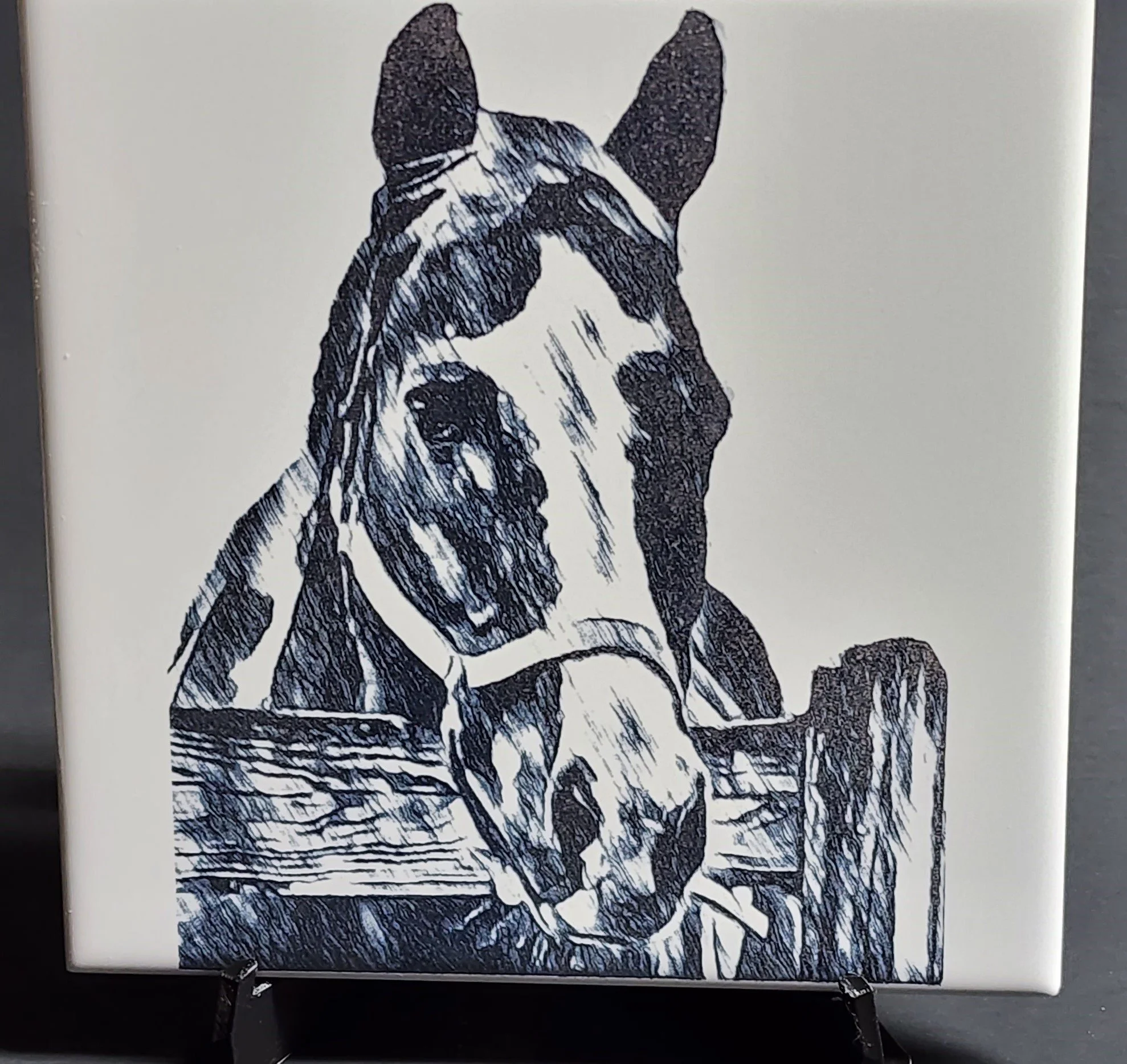 Black and white sketch of a bulldog resting its front paws on a wooden surface.