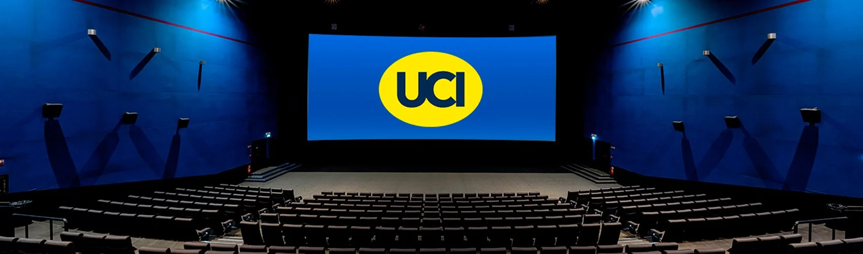Sala cinematografica vuota con grande schermo che mostra il logo UCI.