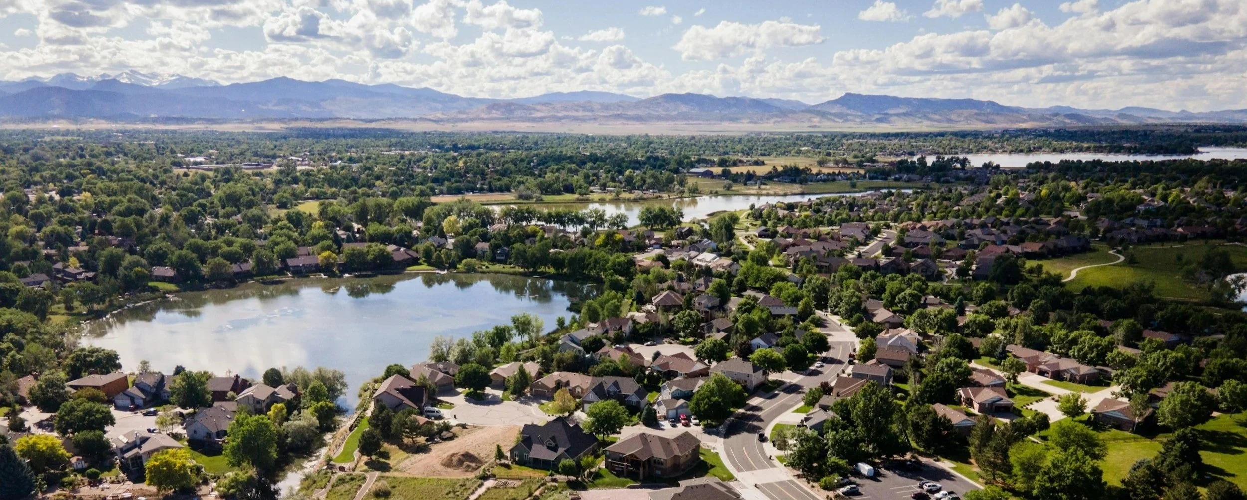 Aerial view of Loveland, Colorado homes and lake with the Front Range mountains