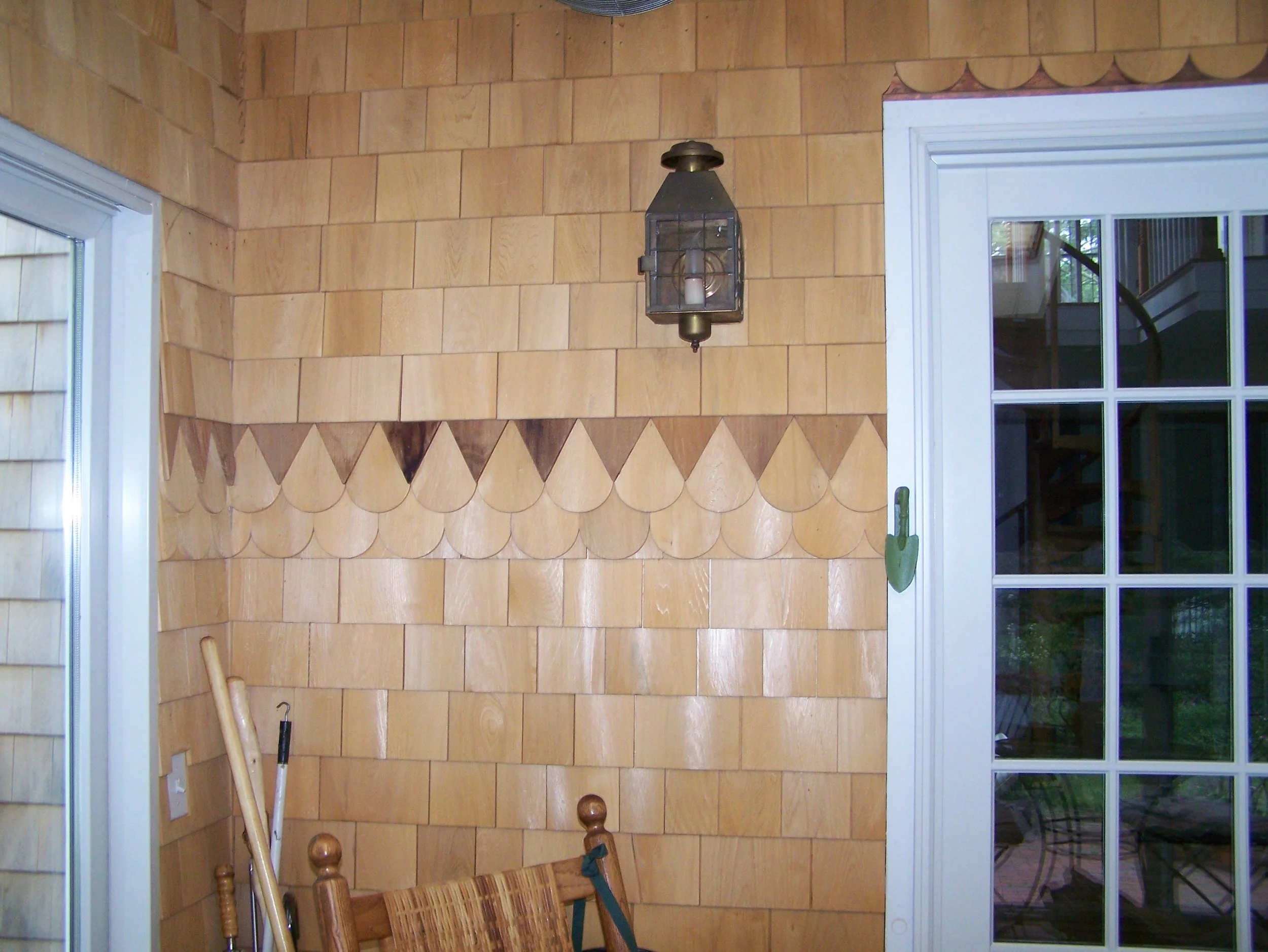 Wood-paneled interior wall with a lantern-style light fixture and a sliding glass door.