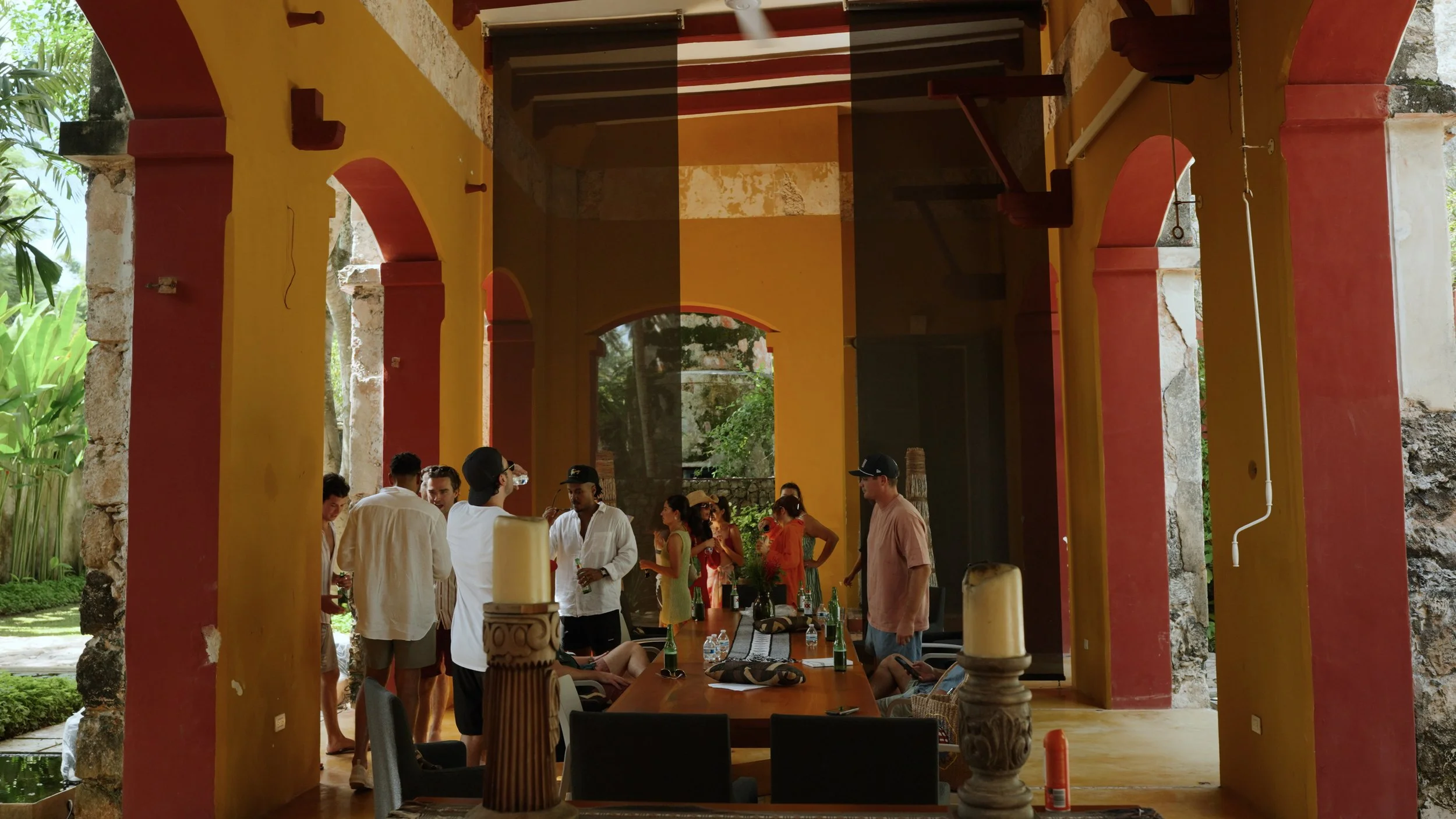 A two-tier wedding cake decorated with pink hearts, roses, and horseshoes, with a bride and groom figure topper in wedding attire, standing on the top tier.