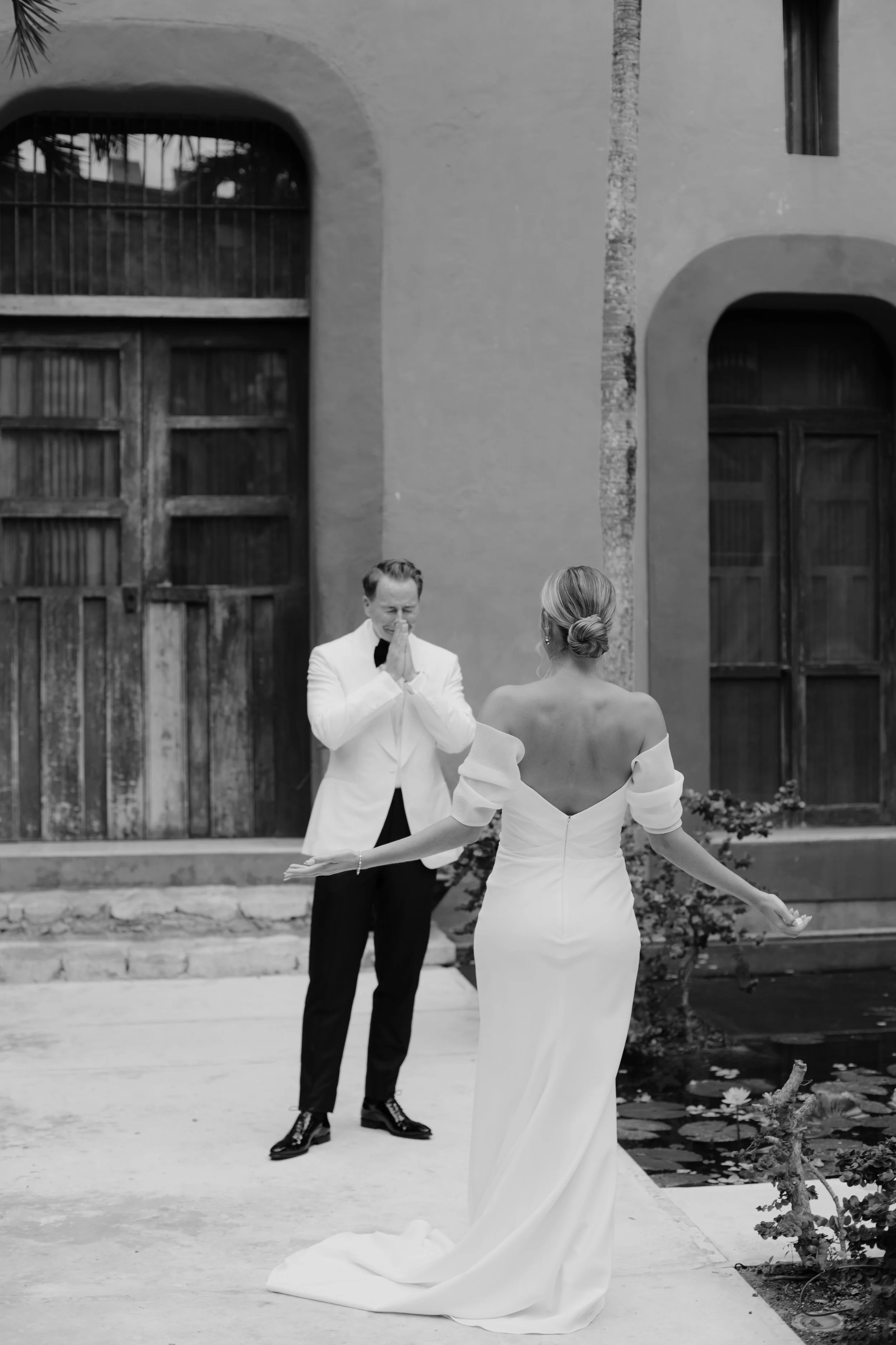 Laurie’s customers, Mariana and Carmen holding hands on a green lawn on their wedding day.