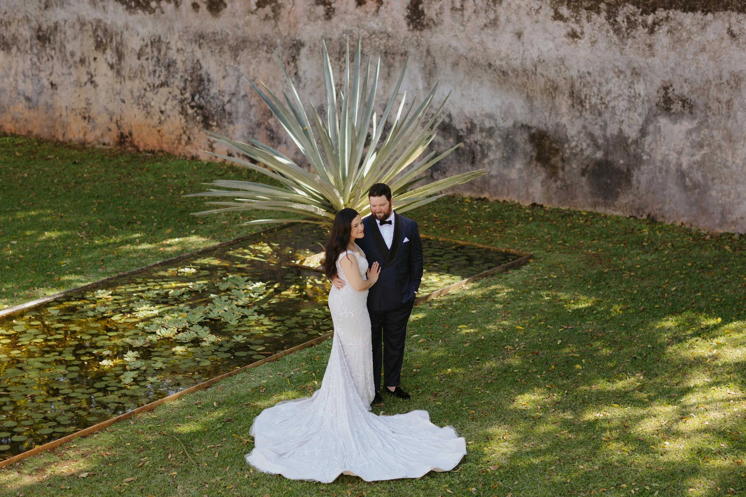 Outdoor wedding ceremony setup with white chairs, floral arrangements, and an arch against a red wooden barn background.
