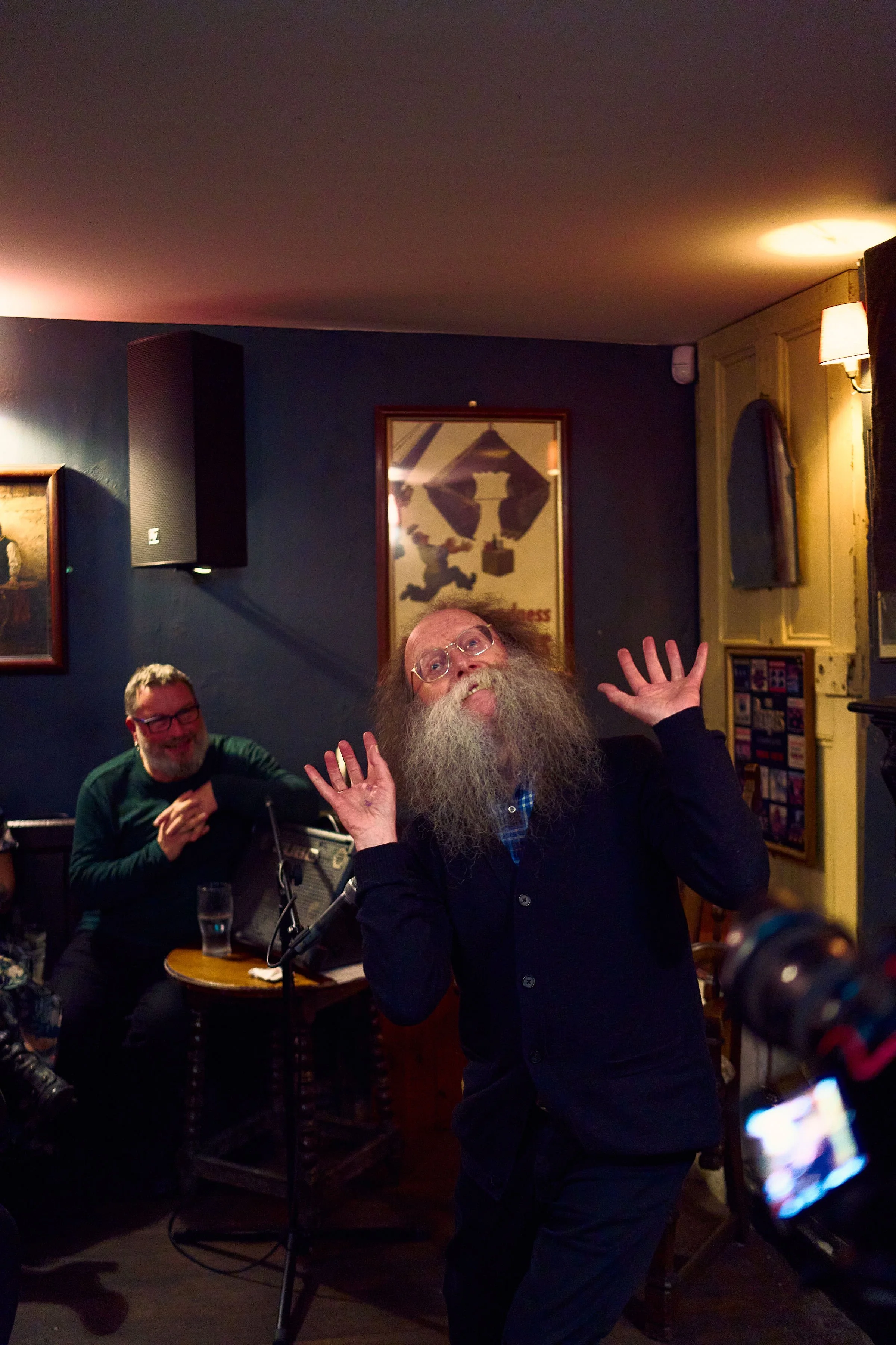 Eddie Lenihan in the grips of dark humor at Sheila Buns in Killorglin, County Kerry. Seán an Seanchaí, is smiling, watching the master tell his tales. An Feile Eile, Halloween Festival.