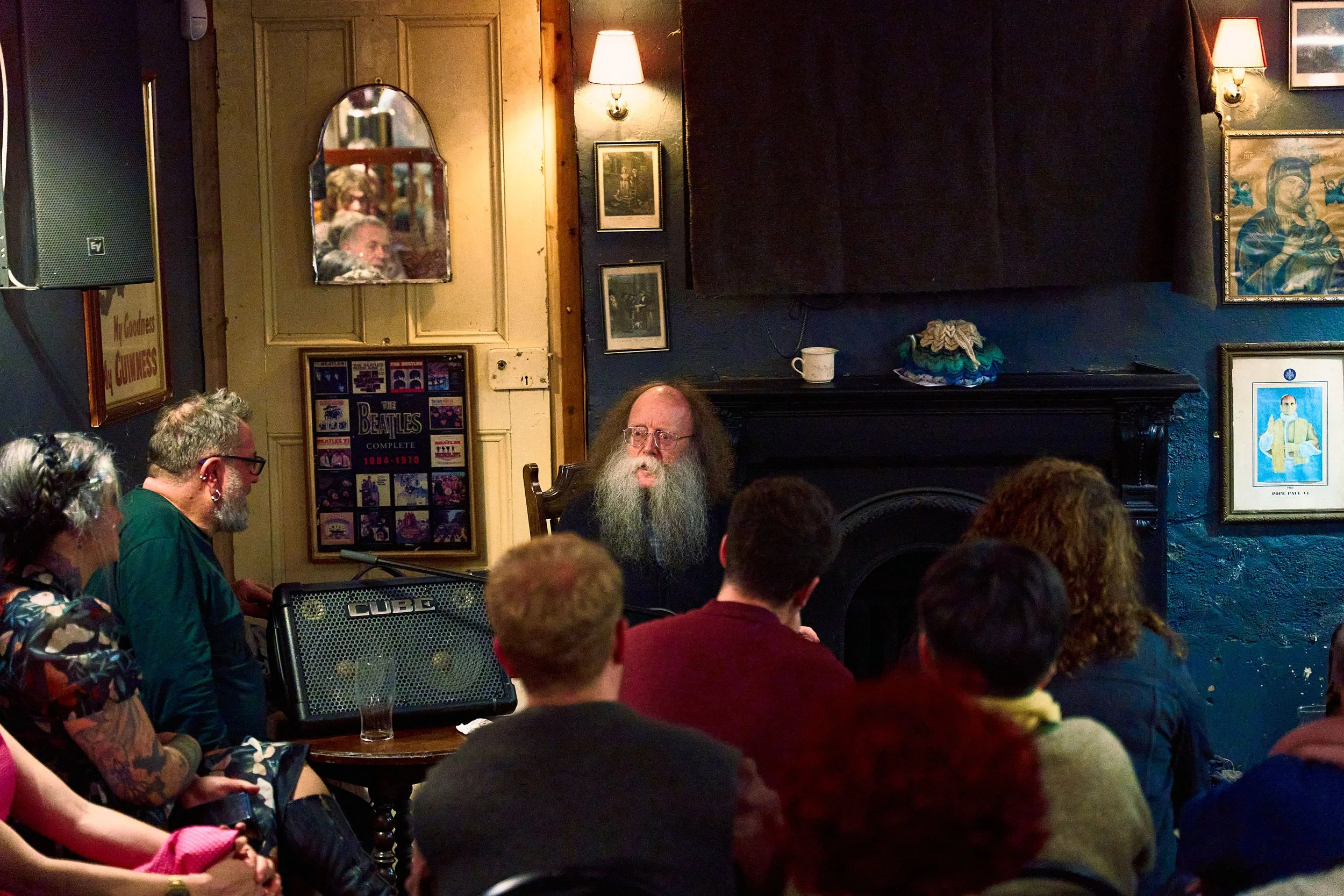 Eddie Lenihan in the grips of dark humor at Sheila Buns in Killorglin, County Kerry. Seán an Seanchaí, is smiling, watching the master tell his tales. An Feile Eile, Halloween Festival.