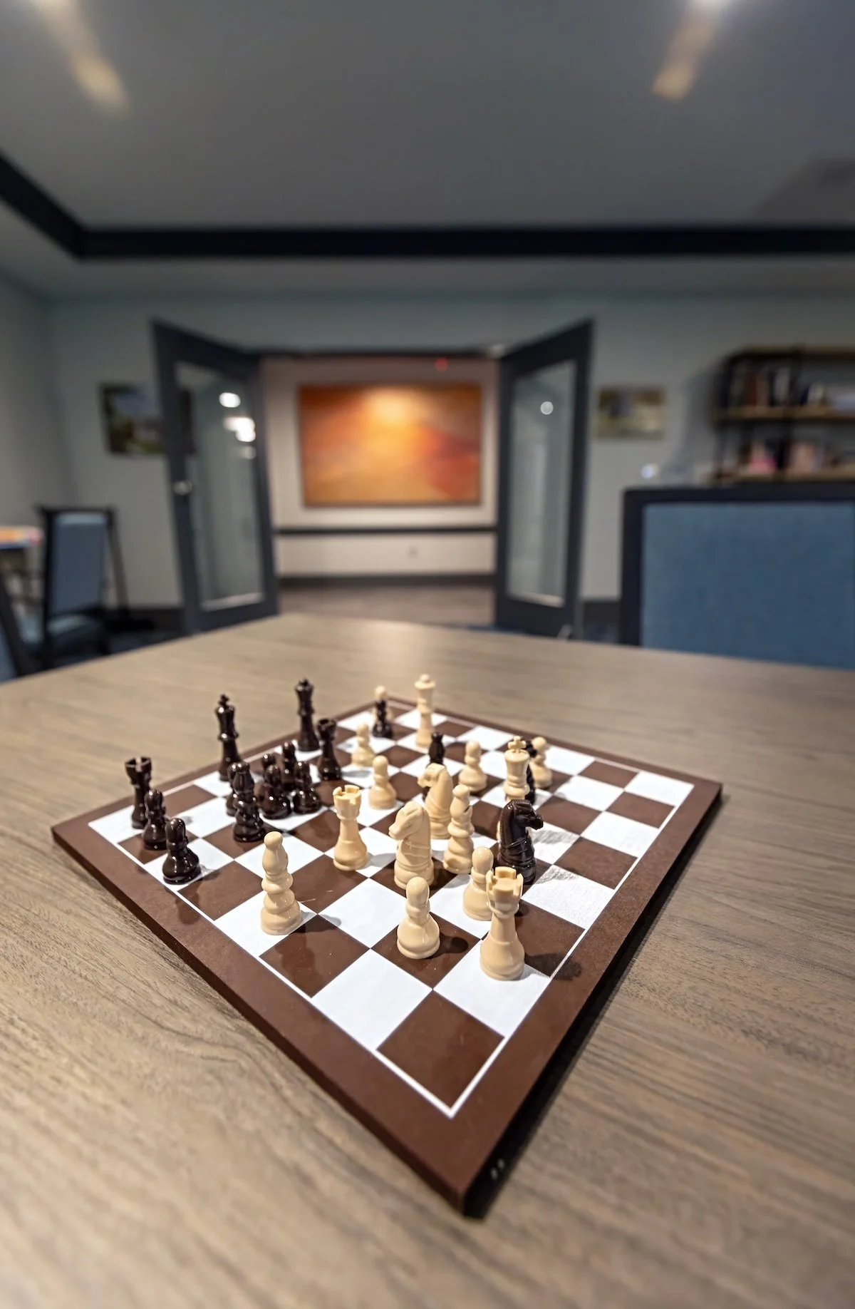 A chessboard with pieces set up during a game, placed on a wooden table at Riverview Senior Living and Memory Care in Juneau Alaska