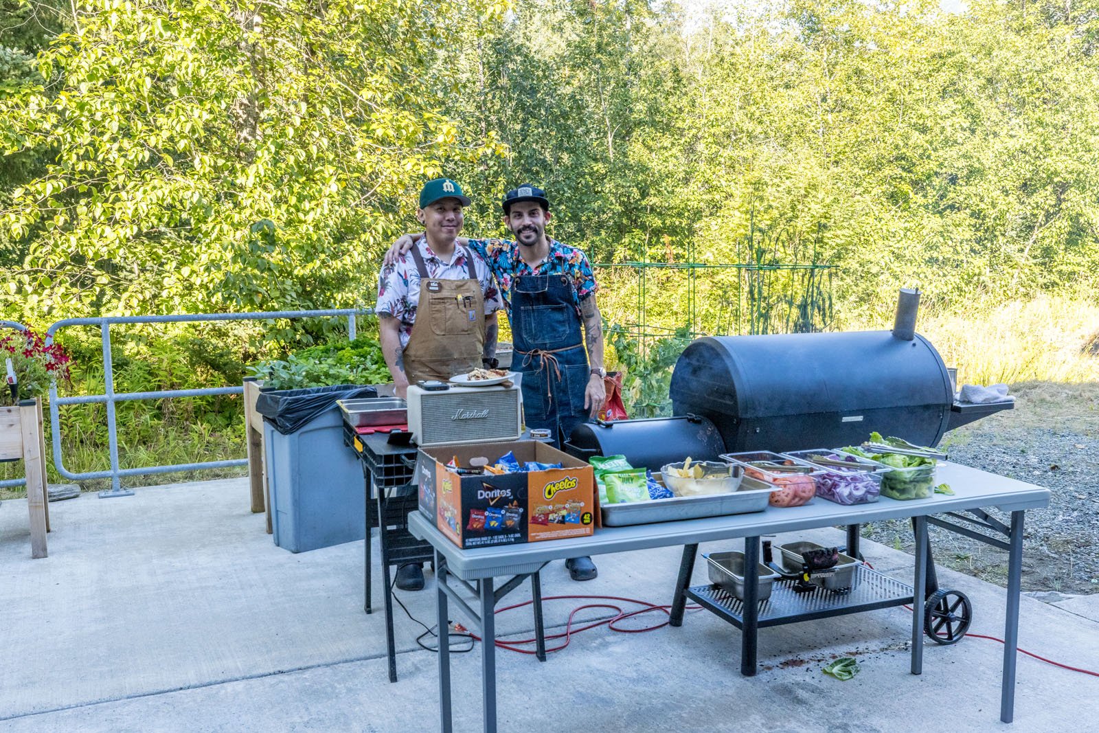 Two men standing behind a barbecue grill at Riverview Senior Living and Memory Care in Juneau Alaska