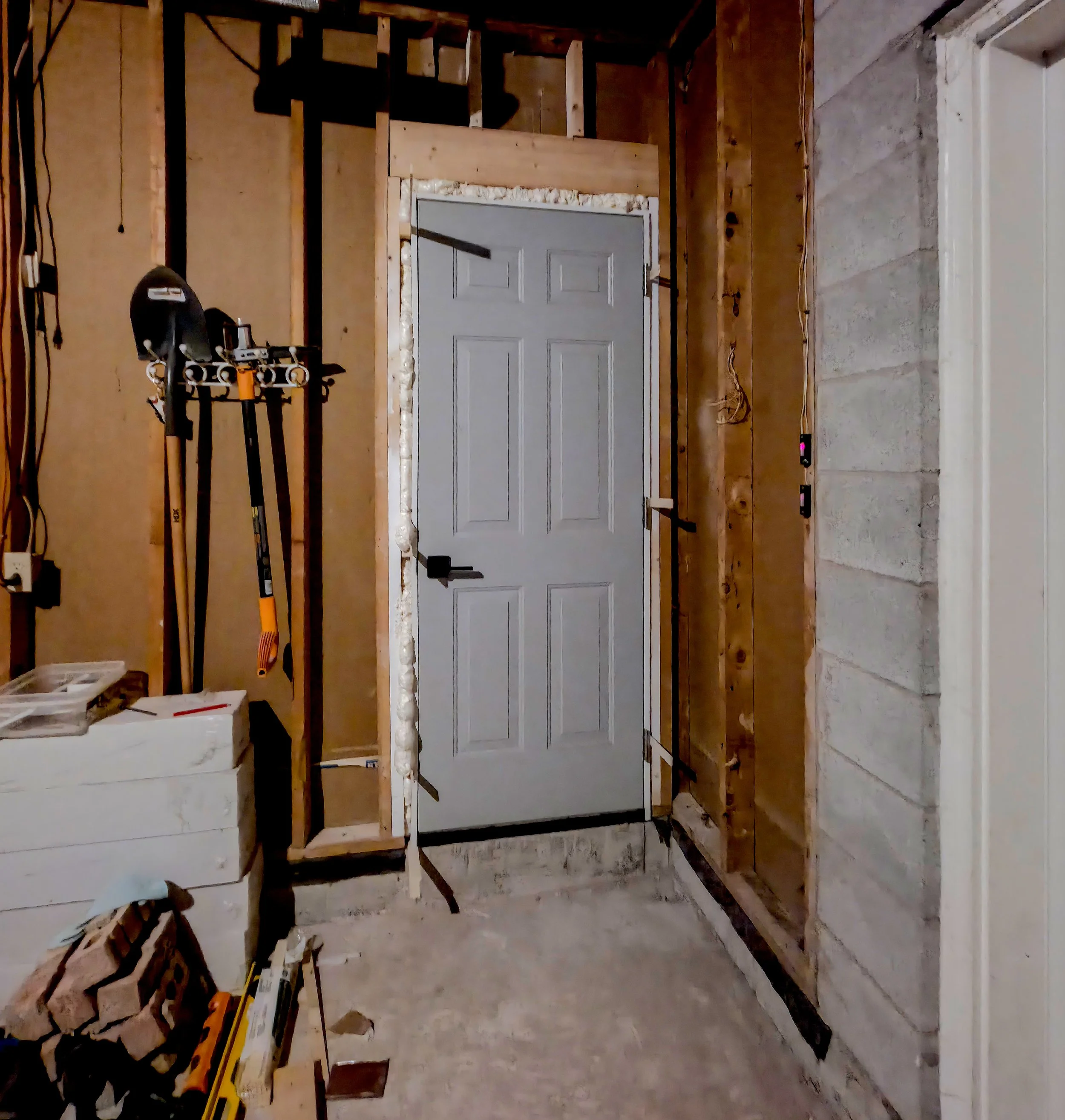 Garage interior with newly installed side door framing and insulation – Pam Arc Inc.