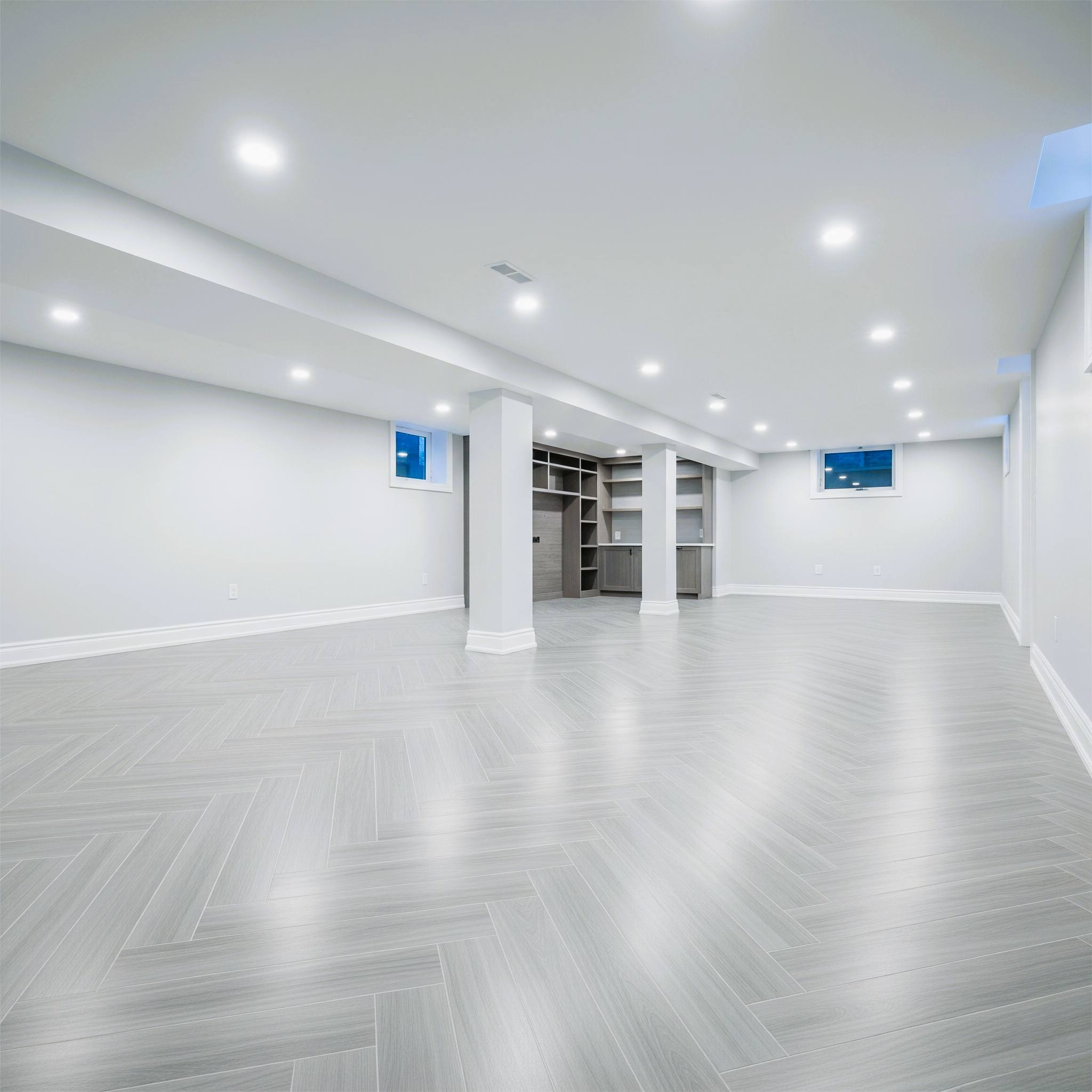 Open concept modern basement with laminate flooring in a Newmarket home.