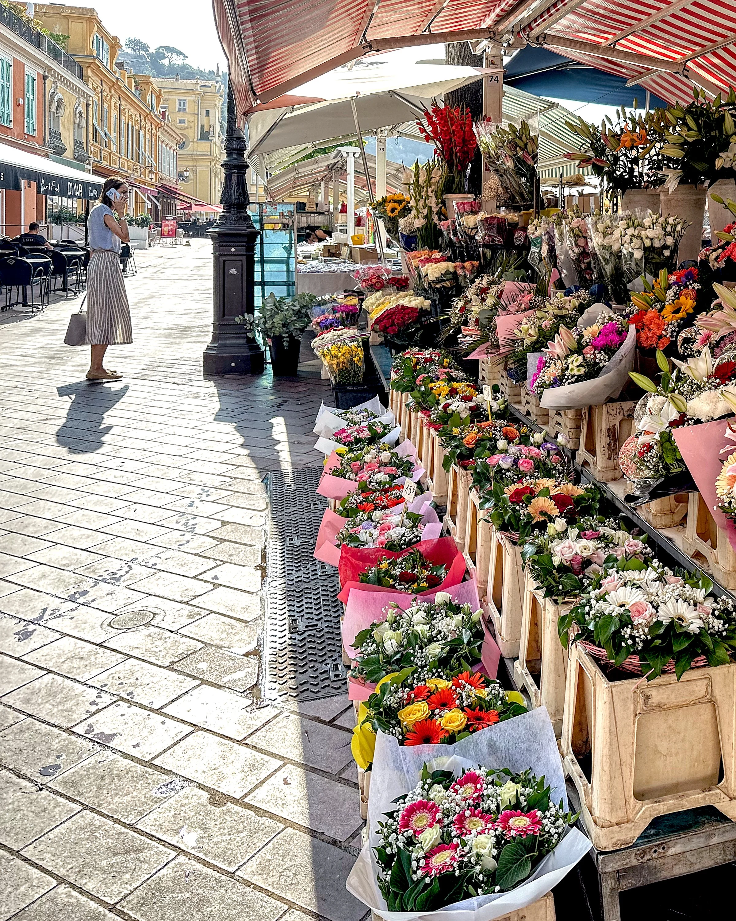 A colorful flower market stall in Nice with many bouquets of flowers on display