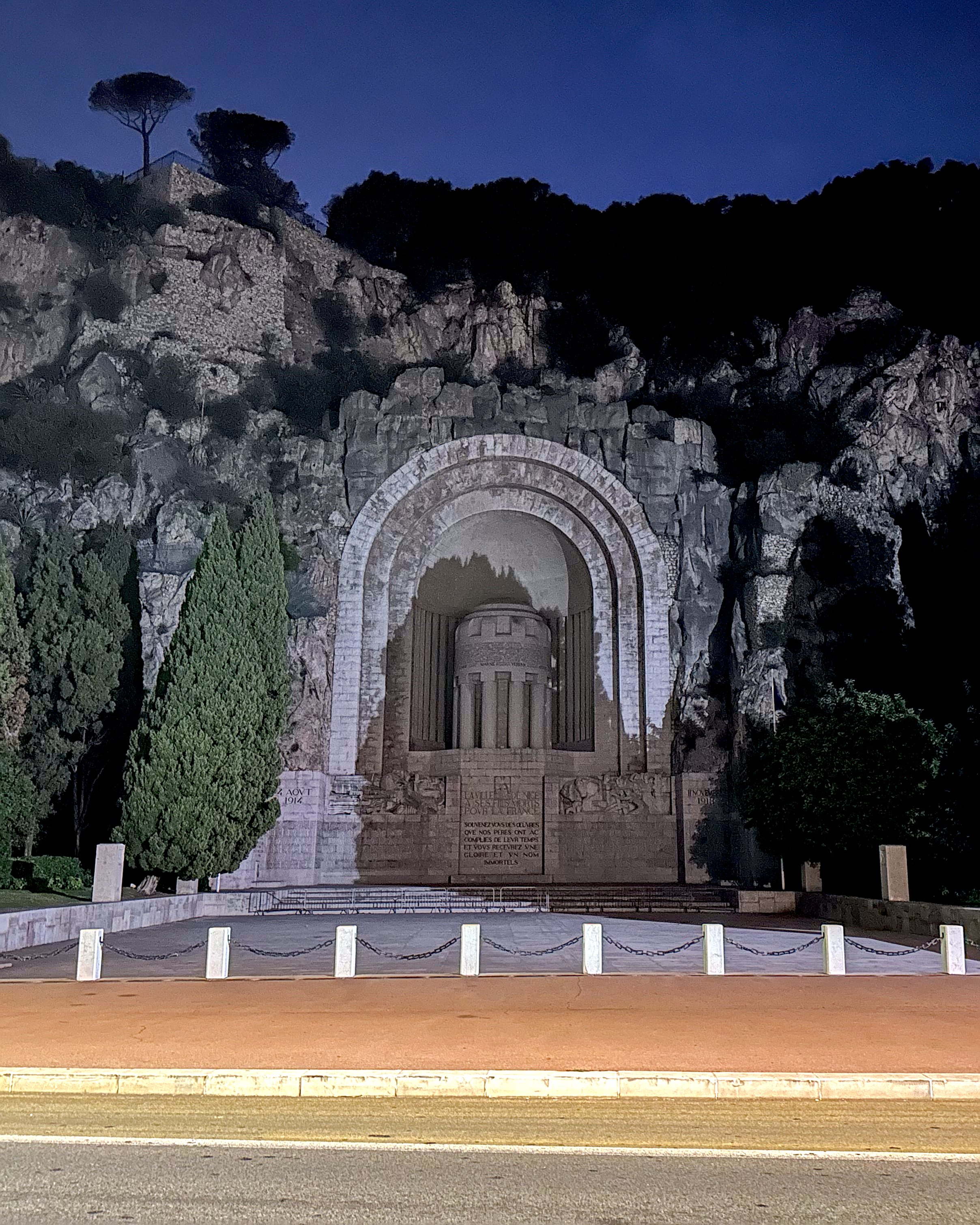 The Monument aux Morts, a large war memorial carved into a cliffside in Nice, lit up at night