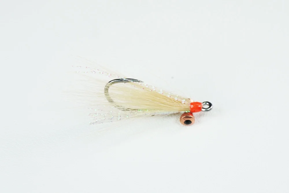 Megafin Gotcha Deep bonefish fly, tan wing and orange head, with metal dumbbell eyes, seen from the side.